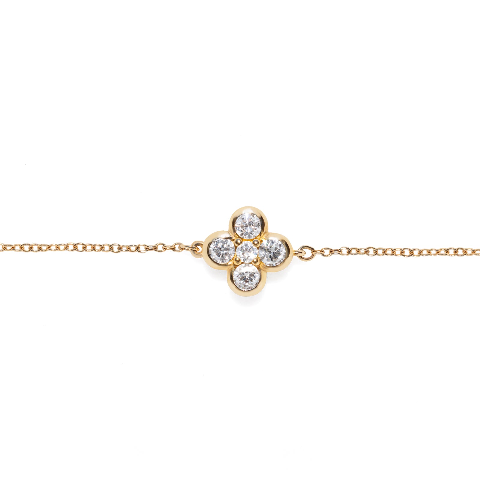 Gold bracelet with a clover-shaped diamond clasp on a white background