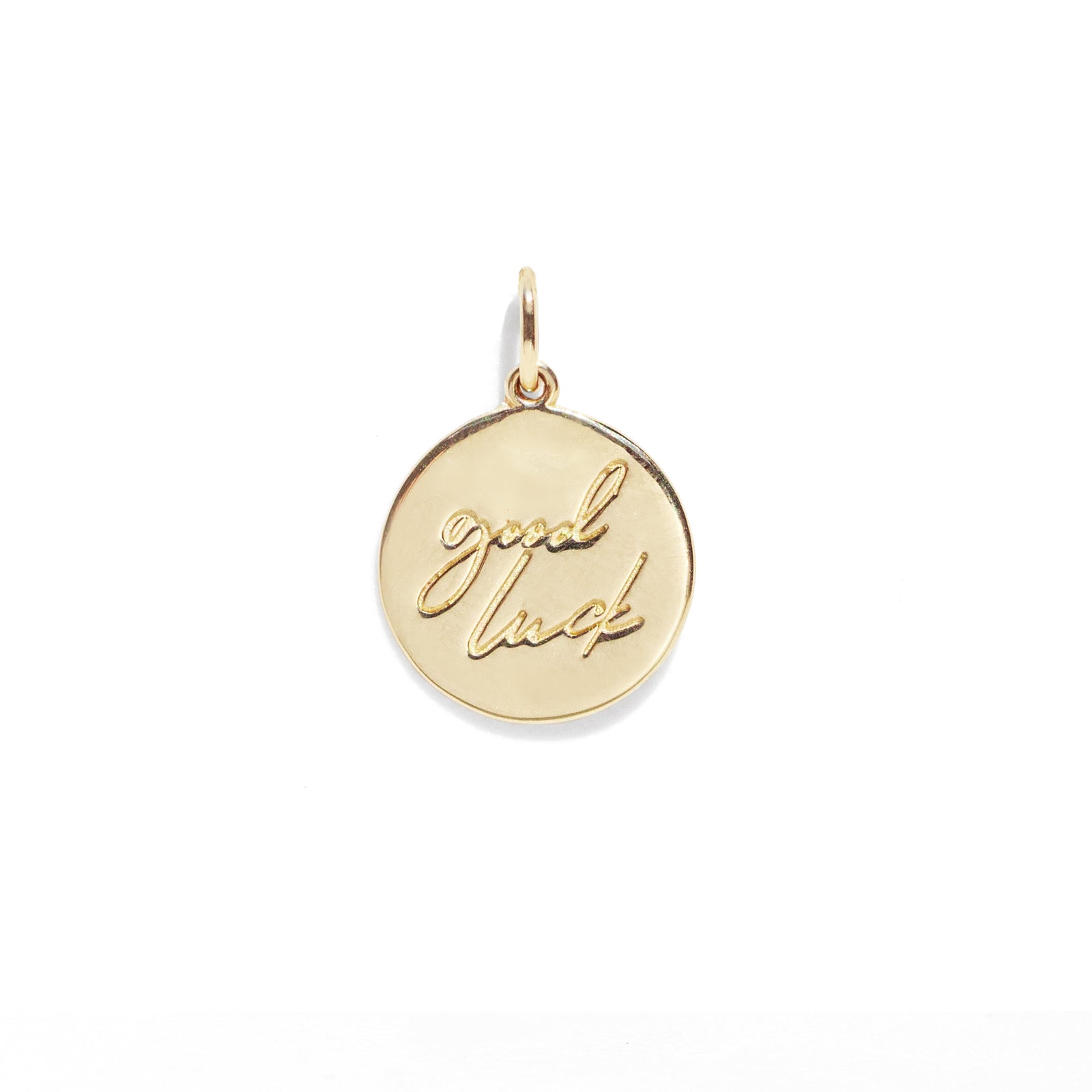 Gold pendant with 'good luck' engraving on a white background