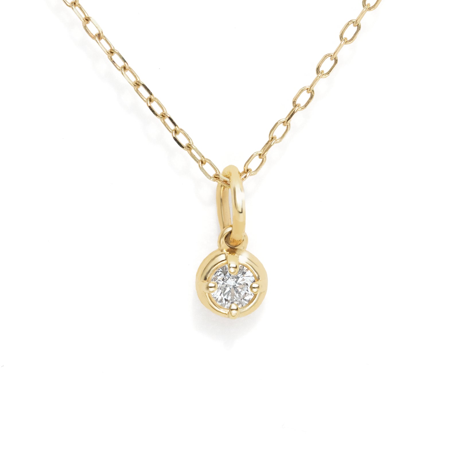 A delicate yellow gold chain necklace with a small round bezel-set diamond pendant, shown against a plain white background.