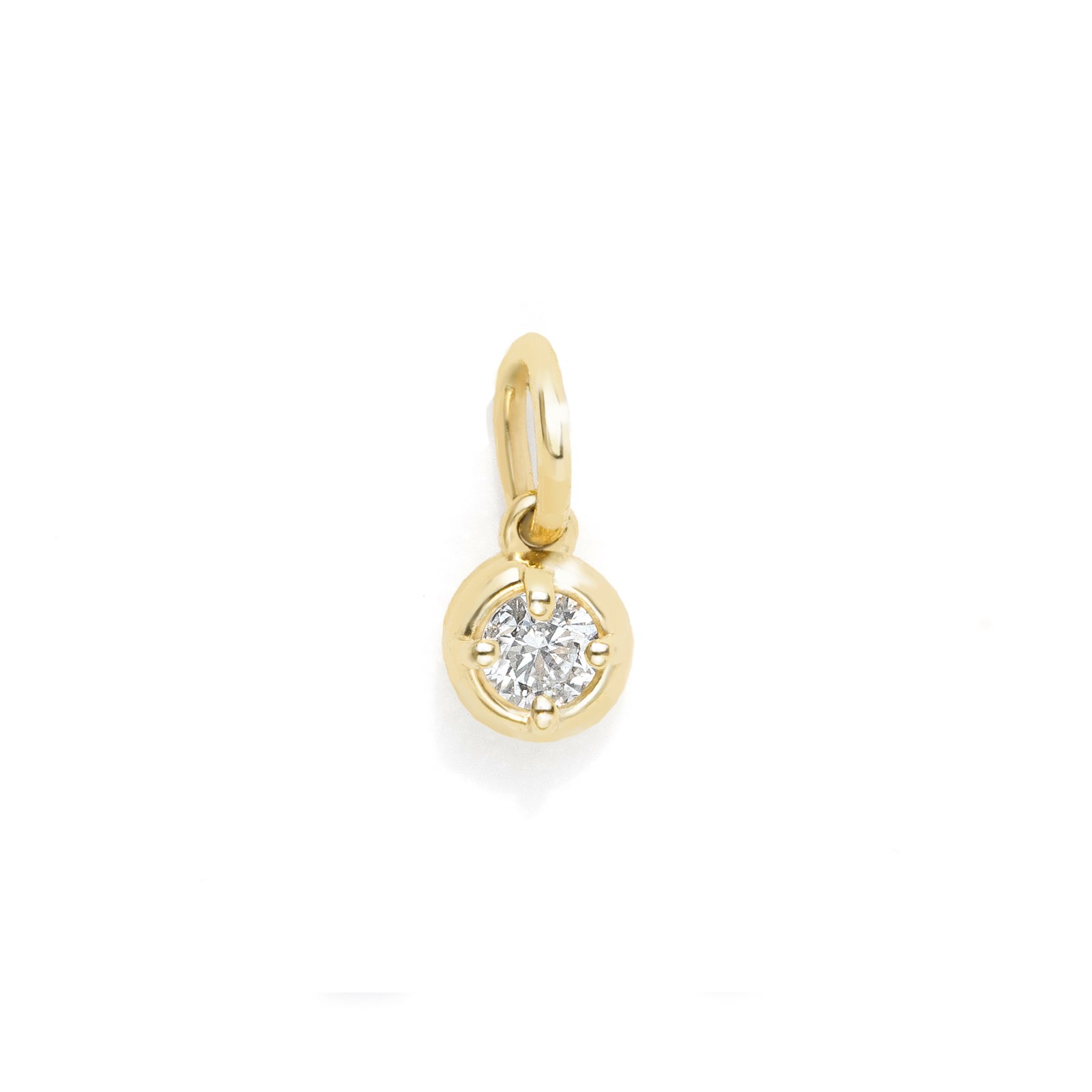 A small gold charm pendant featuring a round bezel-set clear gemstone, shown on a plain white background.