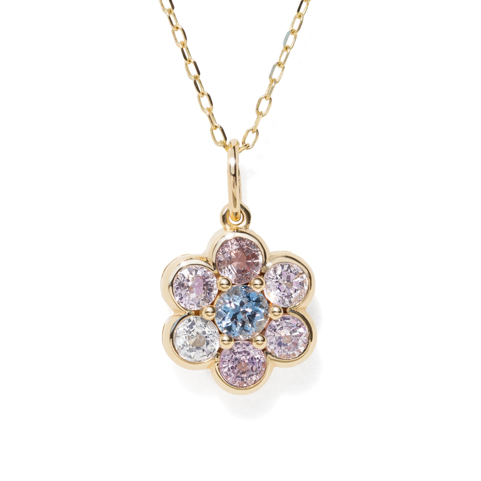A gold flower-shaped pendant necklace featuring a central light blue round gemstone surrounded by six bezel-set round gemstones in pink, purple, and clear, suspended from a delicate gold chain on a white background.