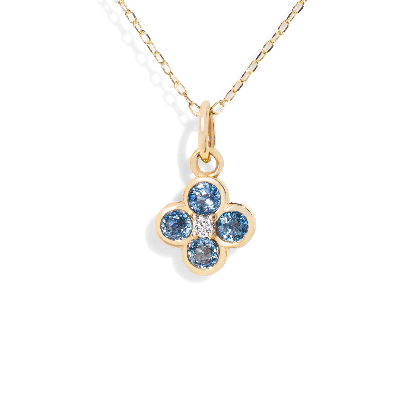 Gold necklace with a flower-shaped pendant featuring blue gemstones on a white background