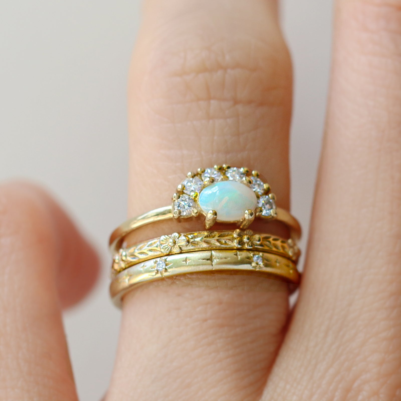 The Opal Diamond Ring features a natural Australian opal set in a half-halo setting. The contoured band is hand-set with an array of baguette and round-cut diamonds to catch the light.