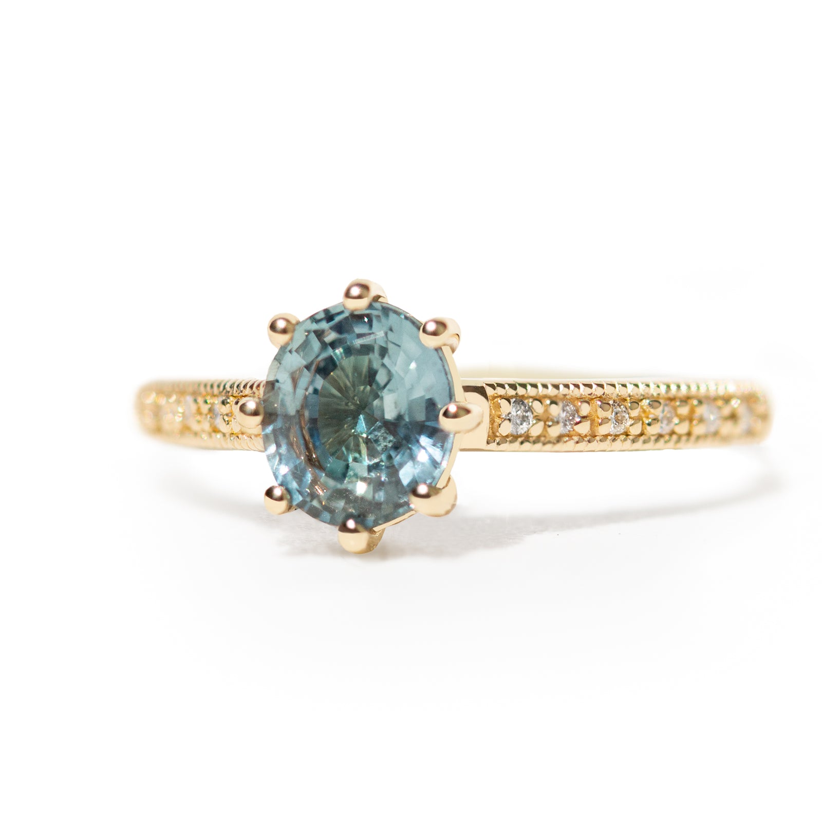The 1.3ct. Oval Montana Sapphire Audrey Ring features a rich blue-green Montana sapphire on a band with delicate milgrain detailing. The elegant 8-prong design securely holds your stone, adding a unique touch. This ring is perfect for those who love timeless and intricate design. 