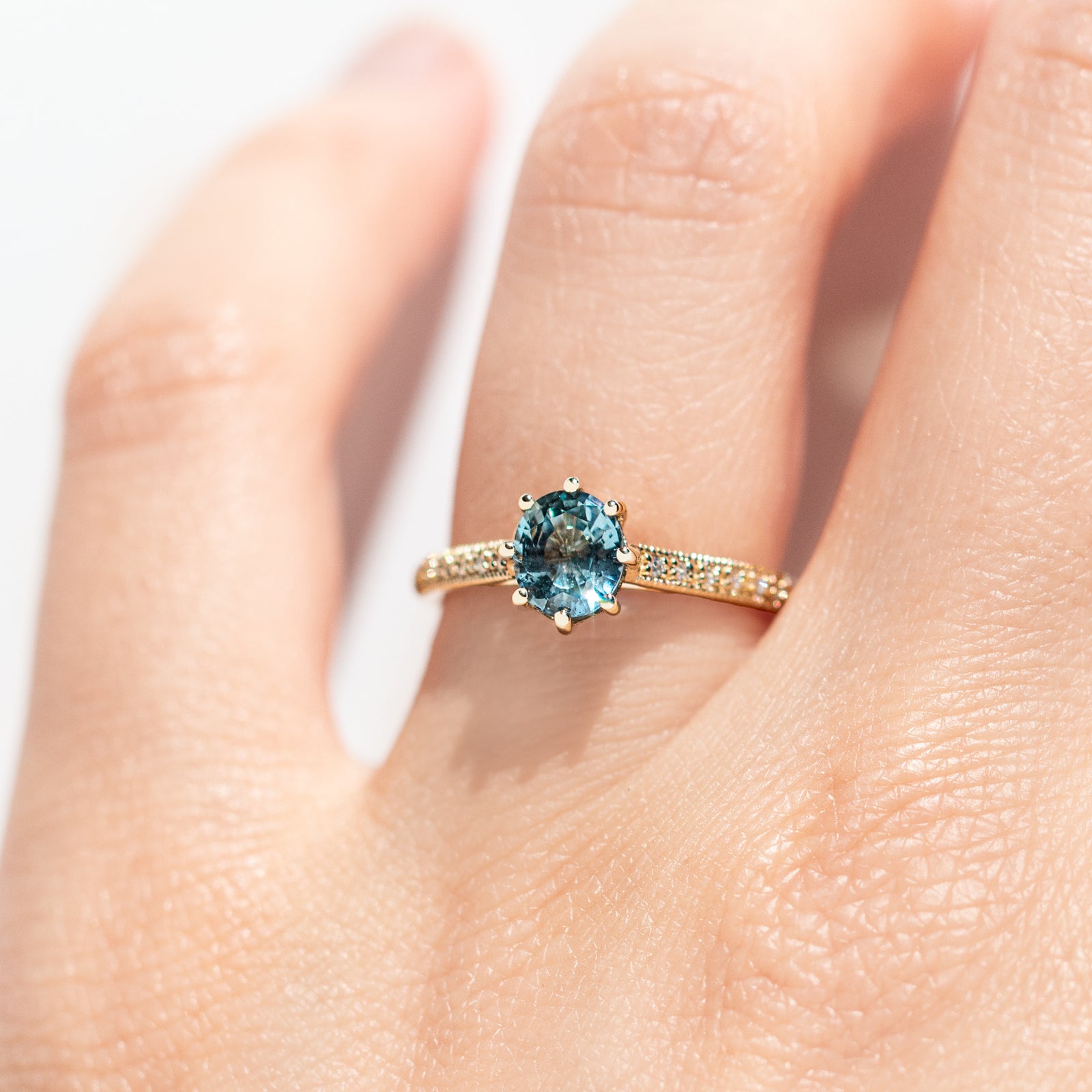 The 1.3ct. Oval Montana Sapphire Audrey Ring features a rich blue-green Montana sapphire on a band with delicate milgrain detailing. The elegant 8-prong design securely holds your stone, adding a unique touch. This ring is perfect for those who love timeless and intricate design. 