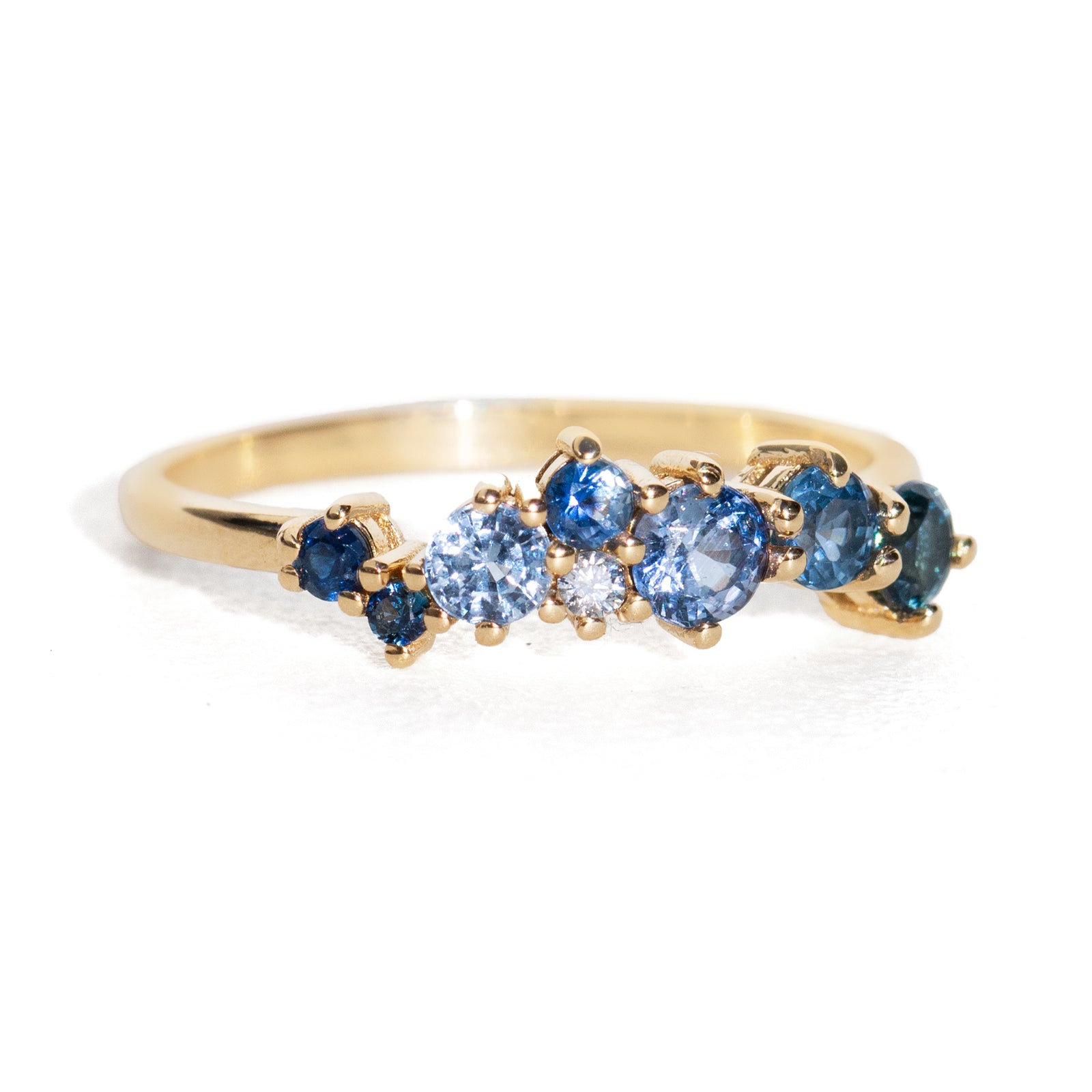 Gold ring with blue gemstones on a white background