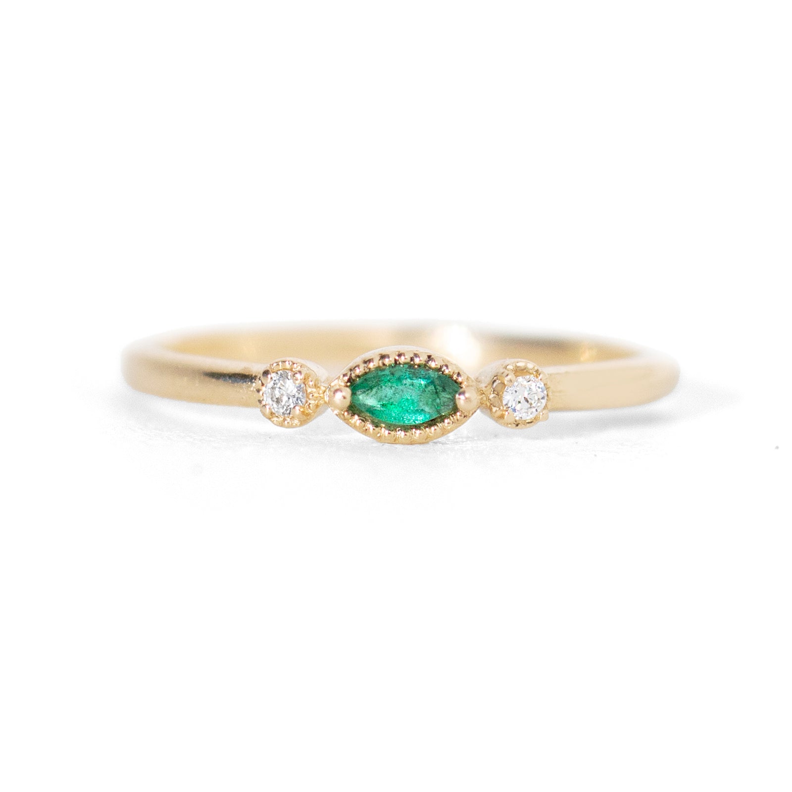Made for vintage lovers, this Nokes Ring features a bold green emerald in a marquise cut, complemented by sparkling diamonds on either side, all set in a beautiful milgrain details. Its understated design makes it ideal for everyday wear, a thoughtful gift, or as a delicate engagement ring.