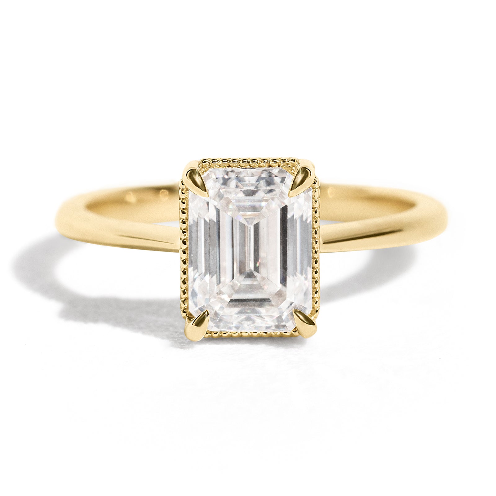 The Hera Ring features a 1.5ct emerald cut diamond or moissanite set in a delicately milgrained setting. This elegant and romantic design effortlessly blends old-world charm with a modern aesthetic. It’s the perfect choice for engagements, milestone celebrations, birthdays, and anniversaries, making it a timeless piece.