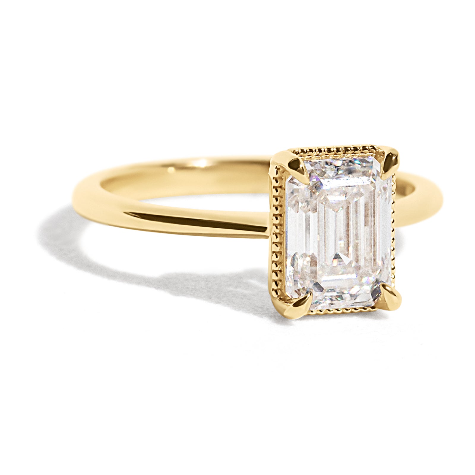 The Hera Ring features a 1.5ct emerald cut diamond or moissanite set in a delicately milgrained setting. This elegant and romantic design effortlessly blends old-world charm with a modern aesthetic. It’s the perfect choice for engagements, milestone celebrations, birthdays, and anniversaries, making it a timeless piece.