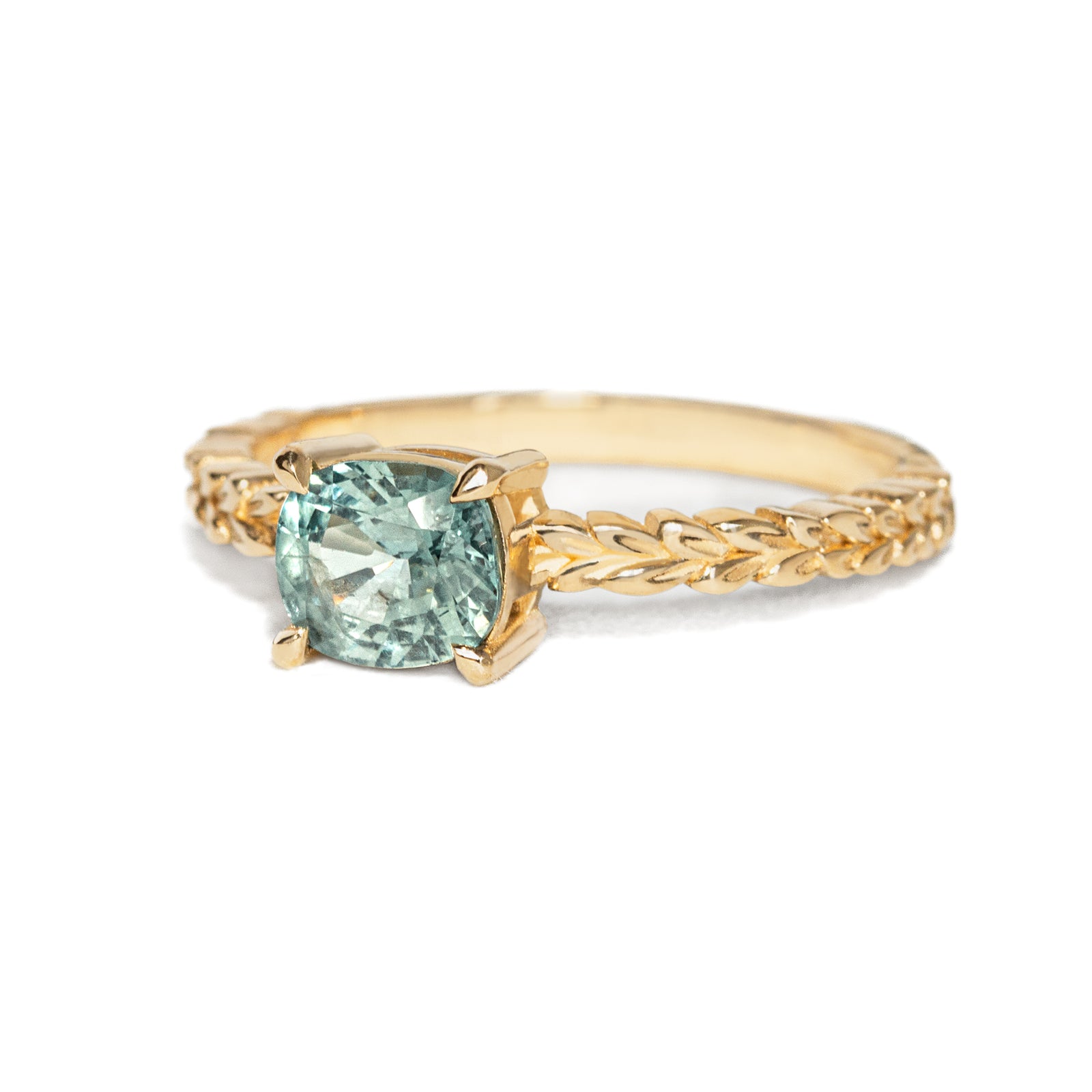 Jamie Park Jewelry -Meadow 1.16ct  Cushion Montana Sapphire Ring Indulge in the beauty of nature with our Meadow Montana Sapphire Ring. Featuring a 1.16ct cushion cut sapphire, east-west set on an olive leaf band, this piece is perfect for an engagement ring or a special gift. The Montana sapphire's blue and green hues make it a truly one-of-a-kind piece to celebrate life's special moments.
