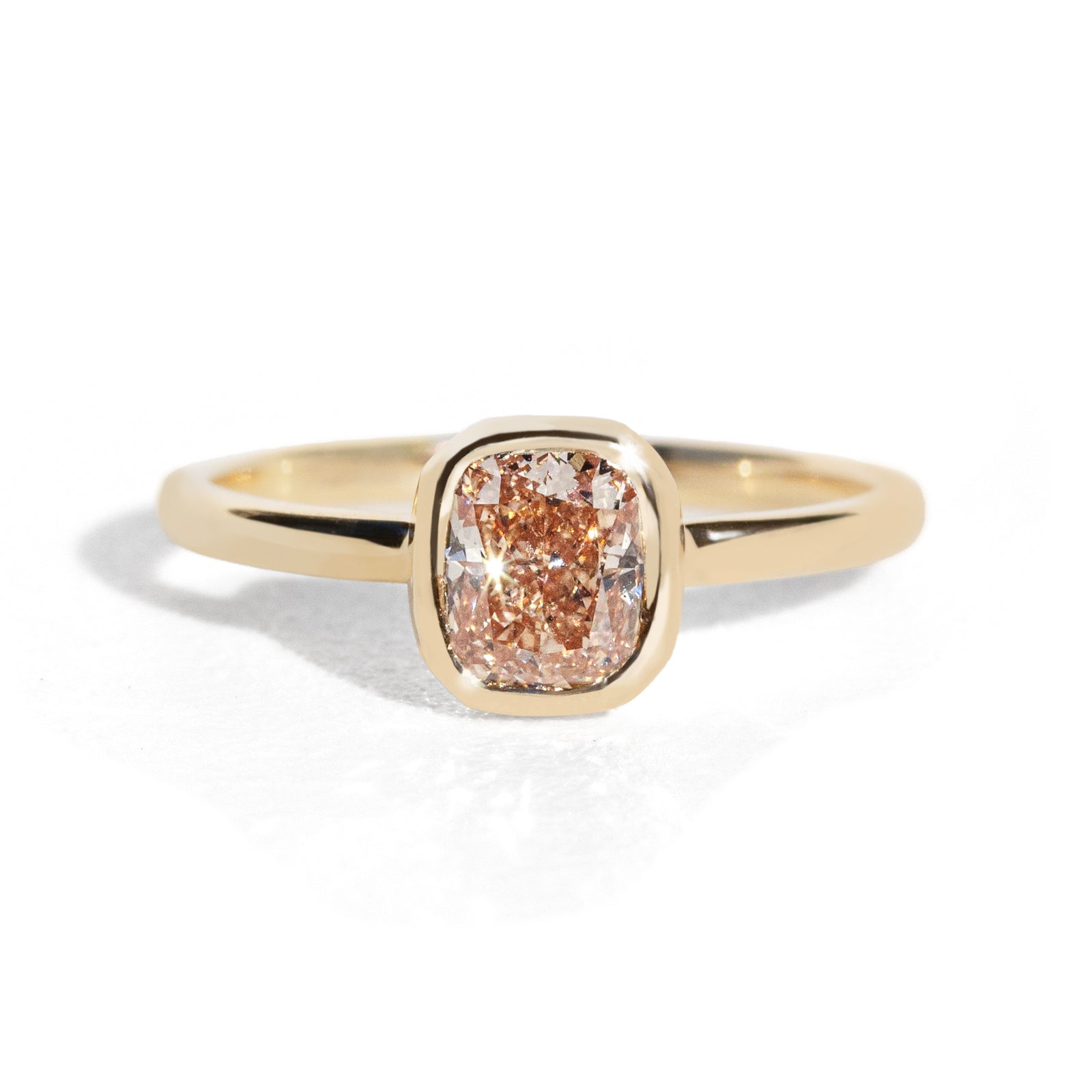 Gold ring with a brown diamond on a white background