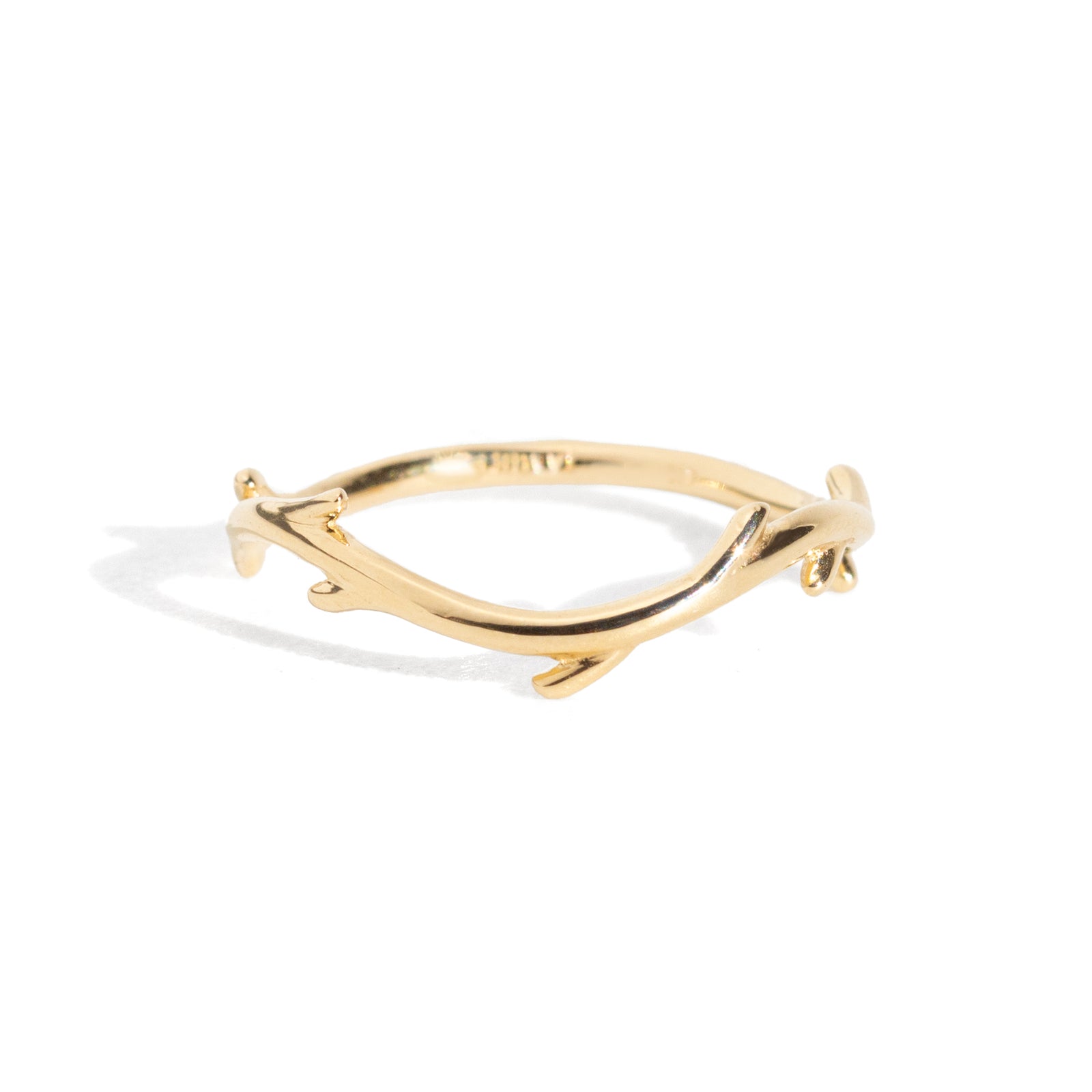 Gold branch-shaped ring on a white background