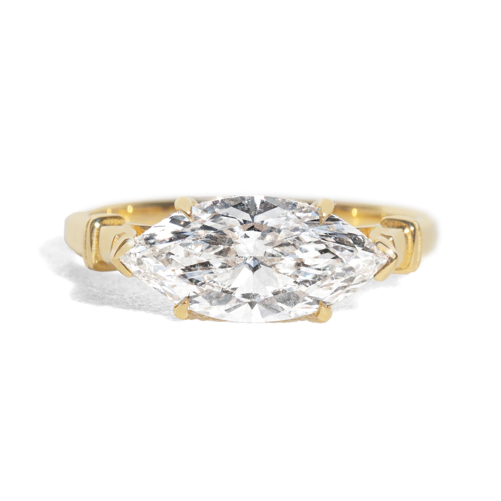 Gold ring with a large marquise shaped diamond on a white background