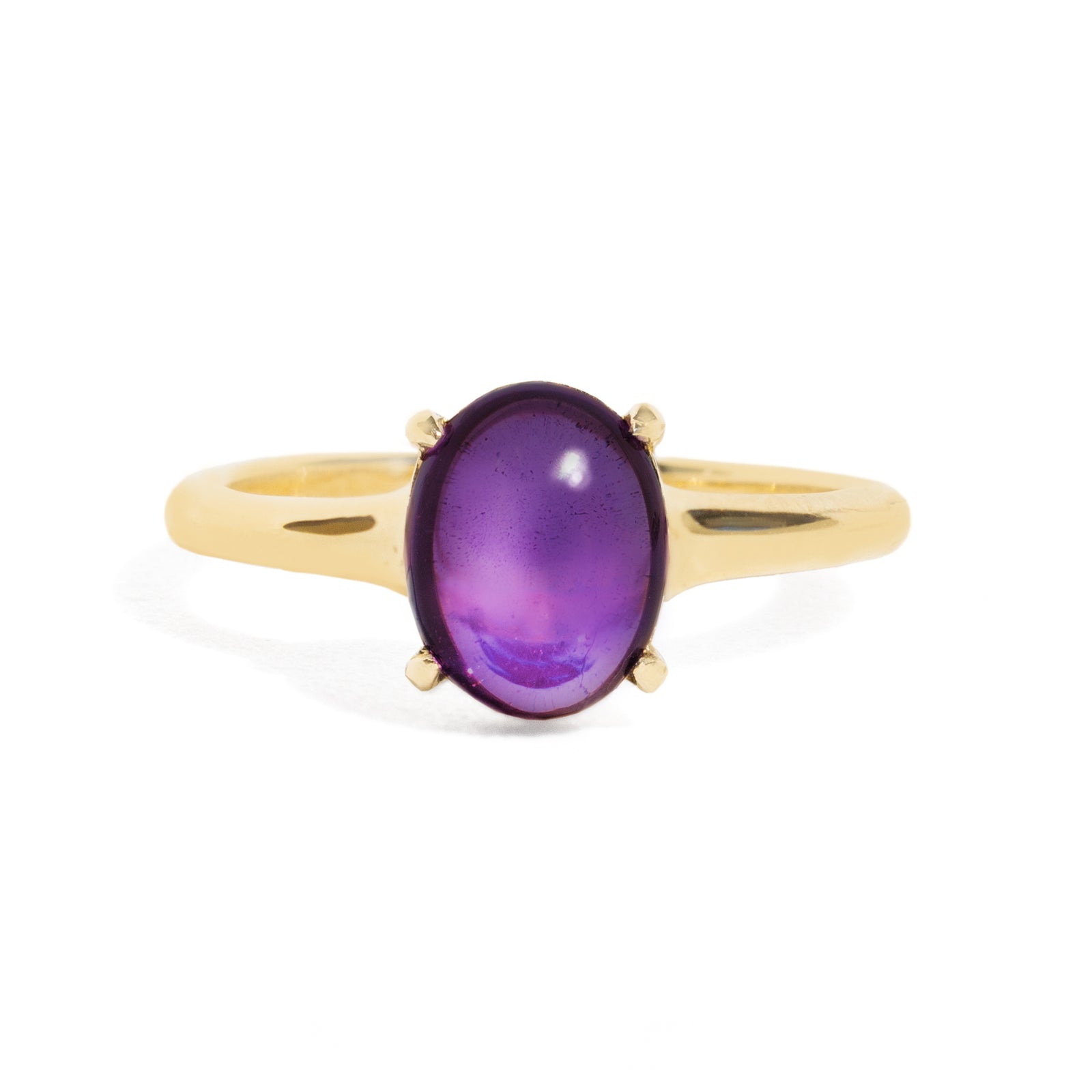 Gold ring with a purple gemstone on a white background