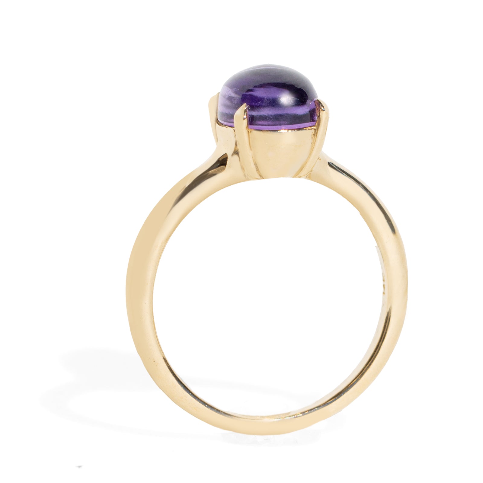 Gold ring with a purple gemstone on a white background