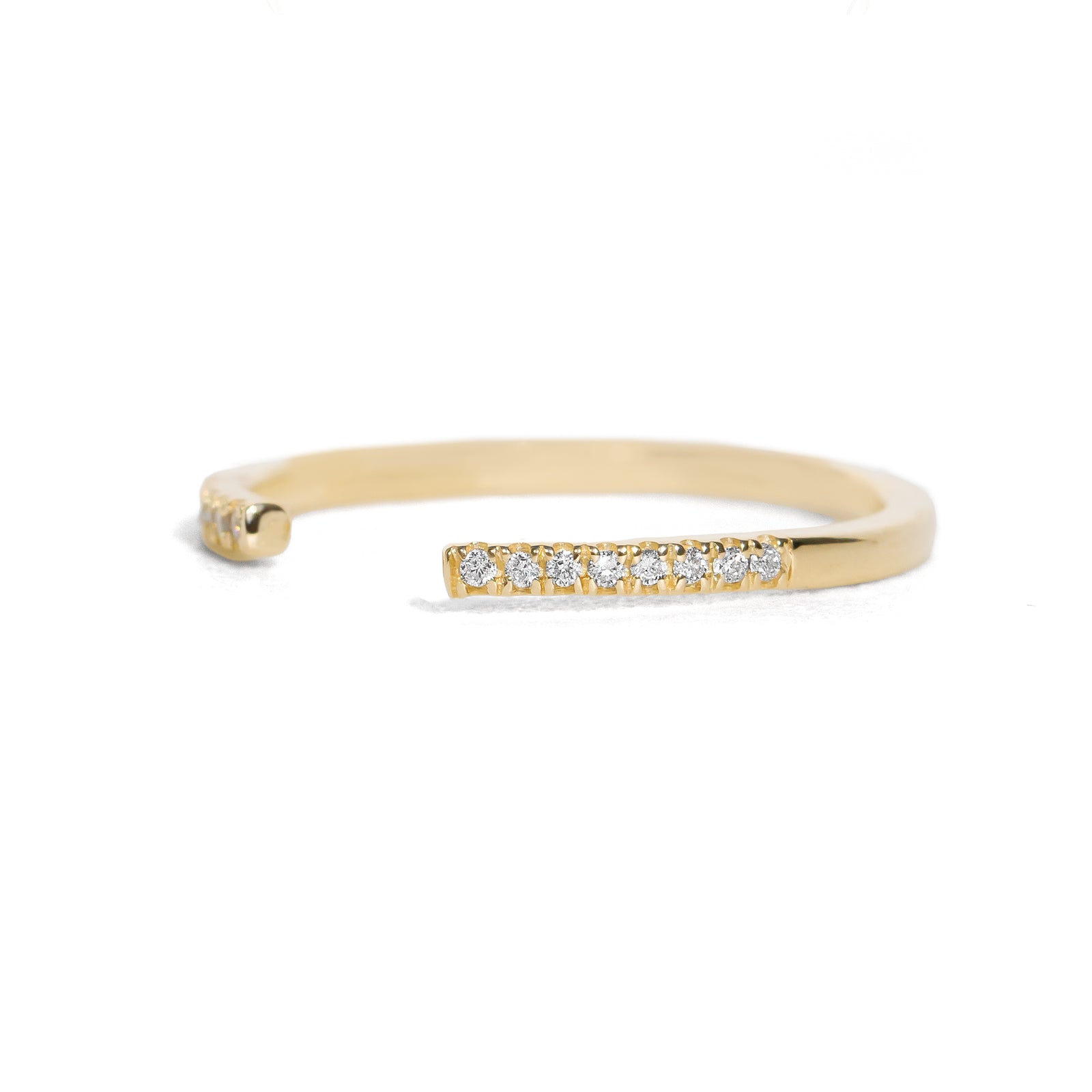 Open gold band with small diamonds on a white background