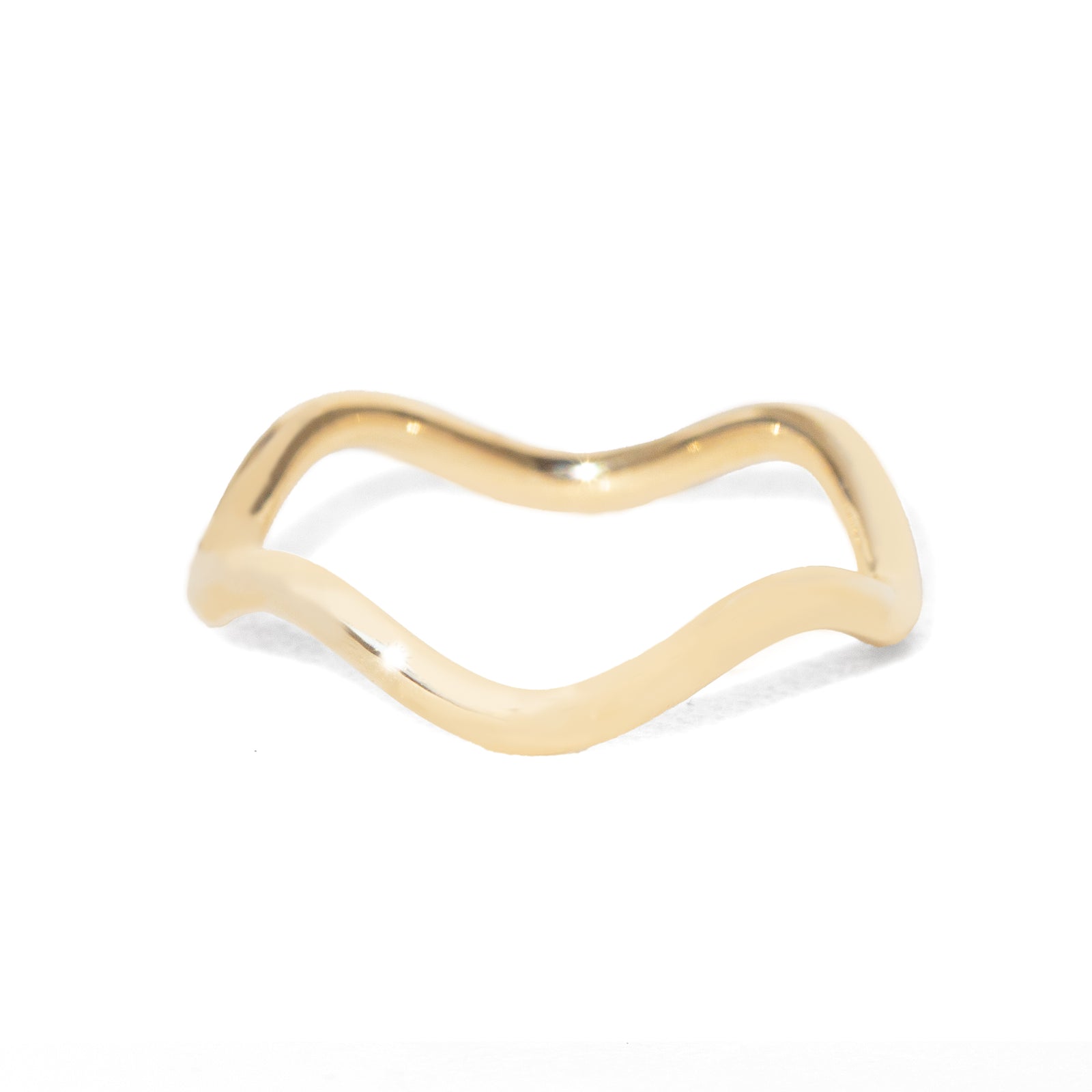 Gold ring with a wavy design on a white background