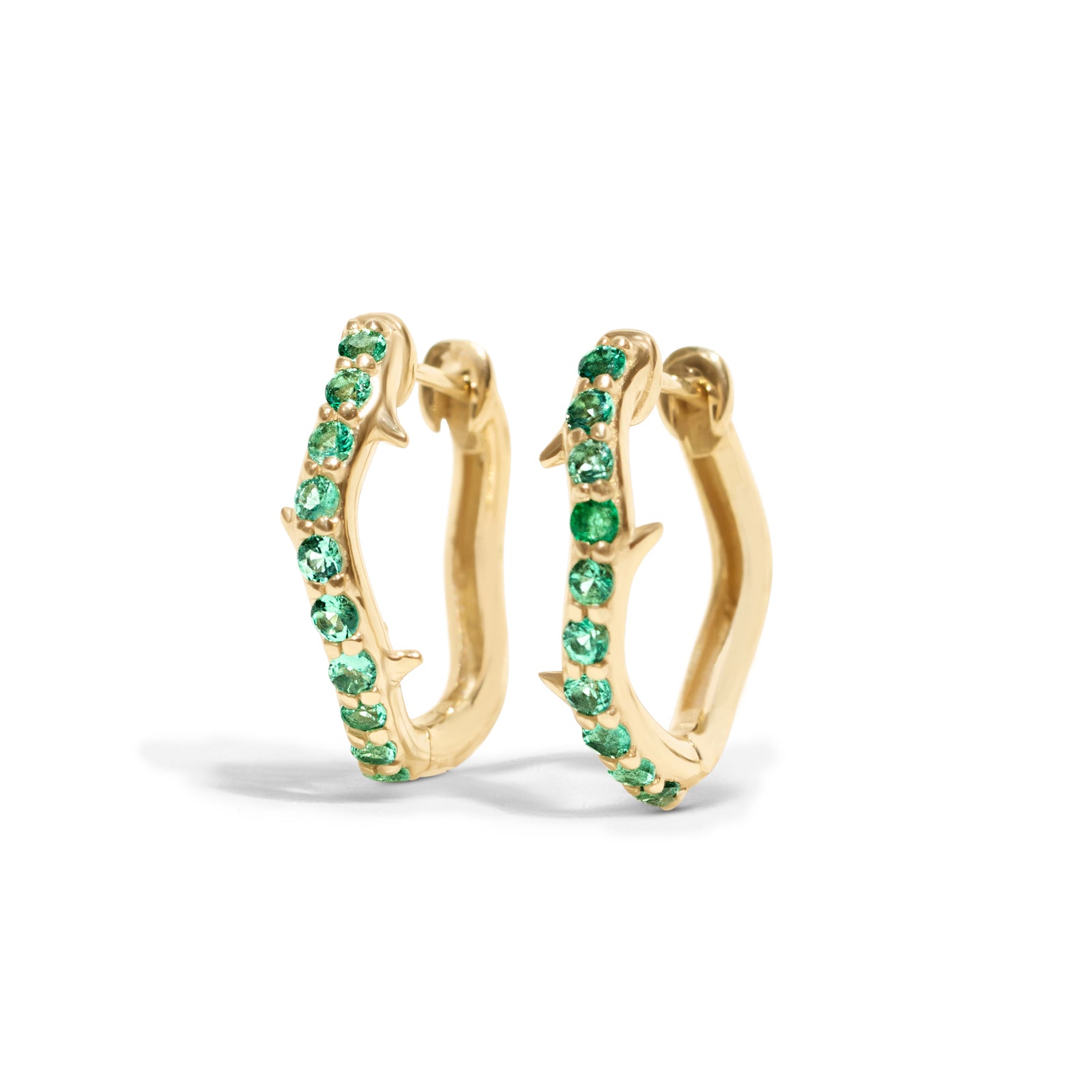 Thorn_Hoops_Emerald_Bold yet refined, the Thorn Emerald Hoop features a delicate thorn silhouette accented with vibrant emeralds. Edgy and elegant, it’s designed for those who love a touch of drama in an understated form.