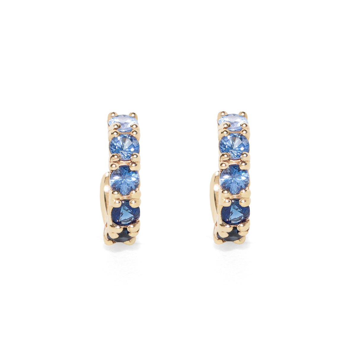 Gold hoop earrings with blue sapphire on a white background