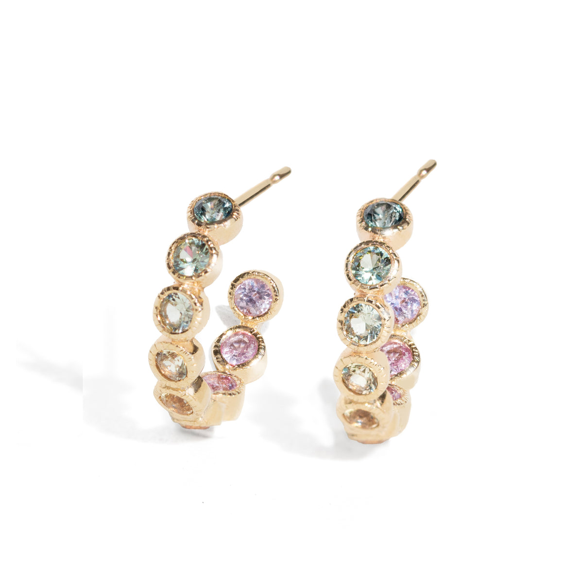 Gold hoop earrings with multicolored gemstones on a white background