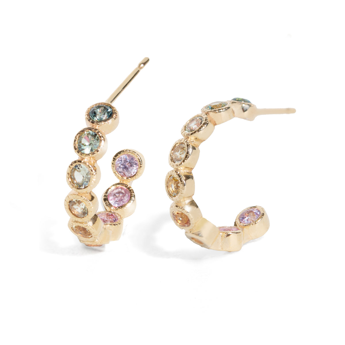 Gold hoop earrings with multicolored gemstones on a white background