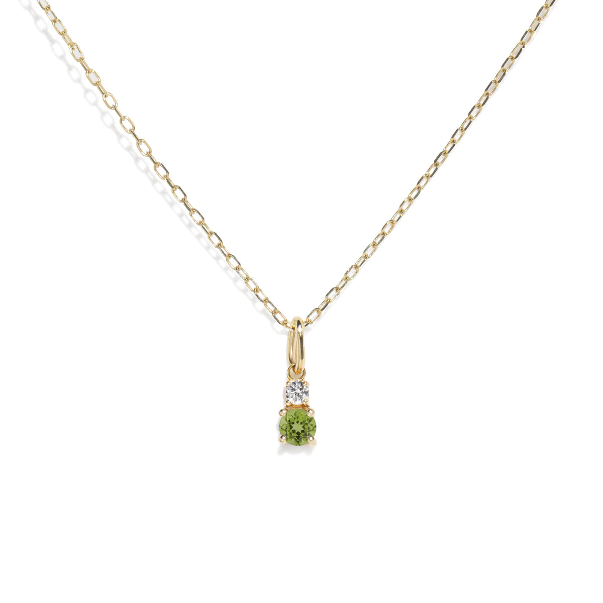 Gold necklace with a green gemstone pendant on a white background