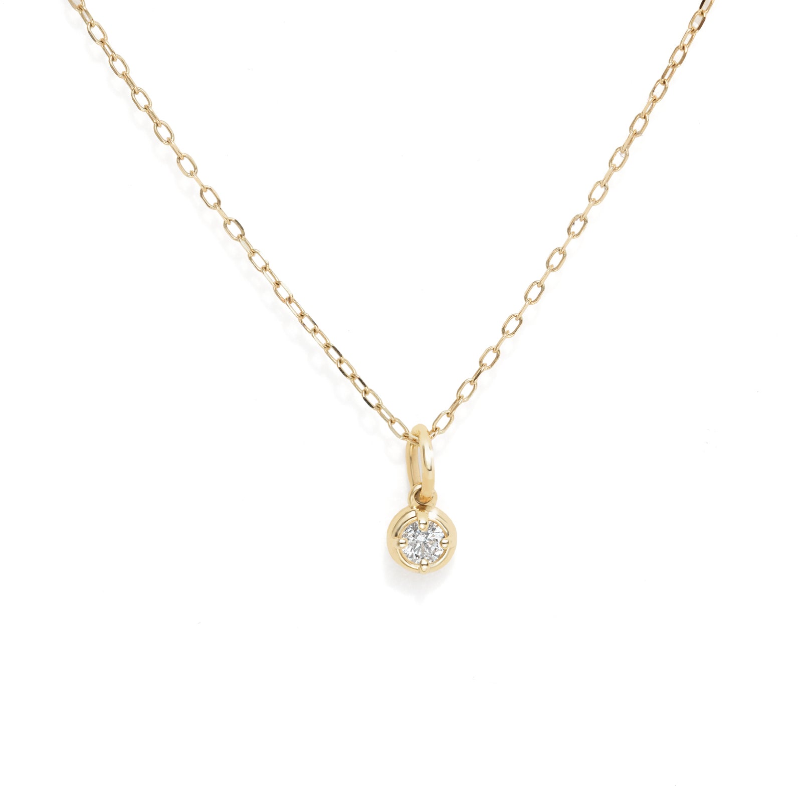 A delicate yellow gold chain necklace with a small round bezel-set clear gemstone pendant, displayed on a clean white background.
