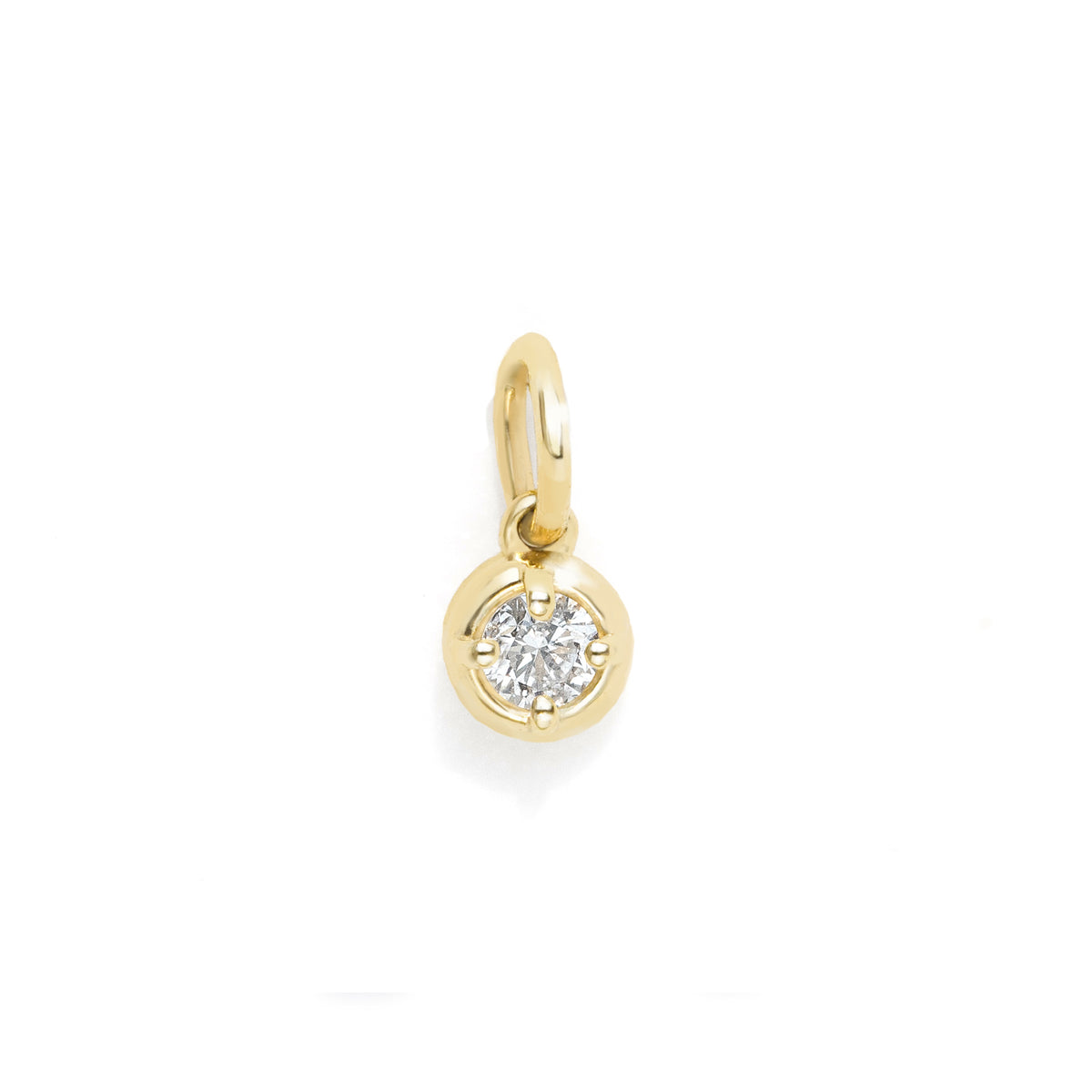 A small gold charm pendant featuring a round bezel-set clear gemstone, shown on a plain white background.