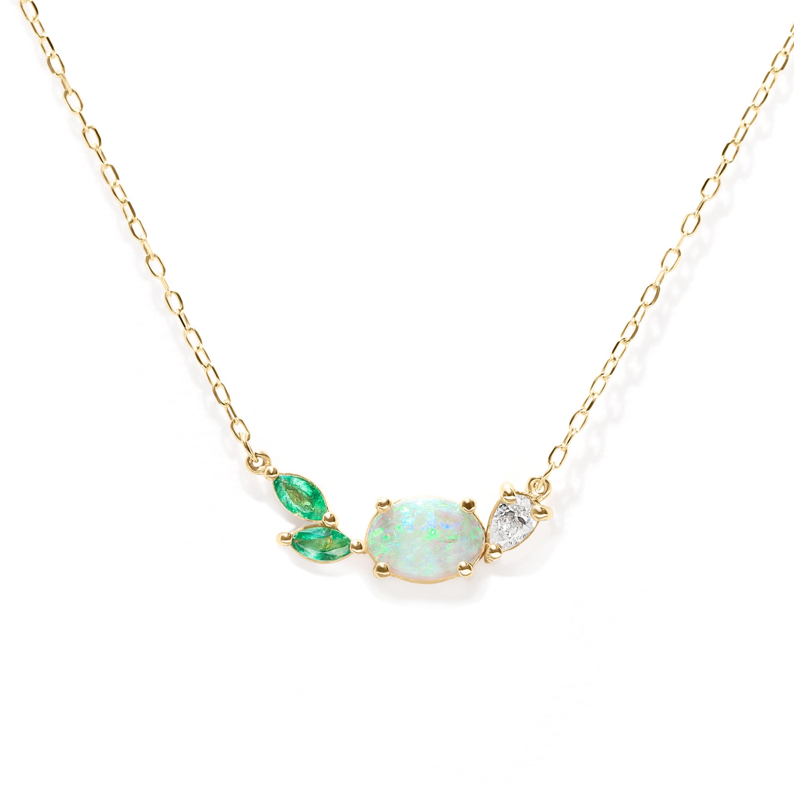 Necklace with green and opal gemstones on a gold chain against a white background