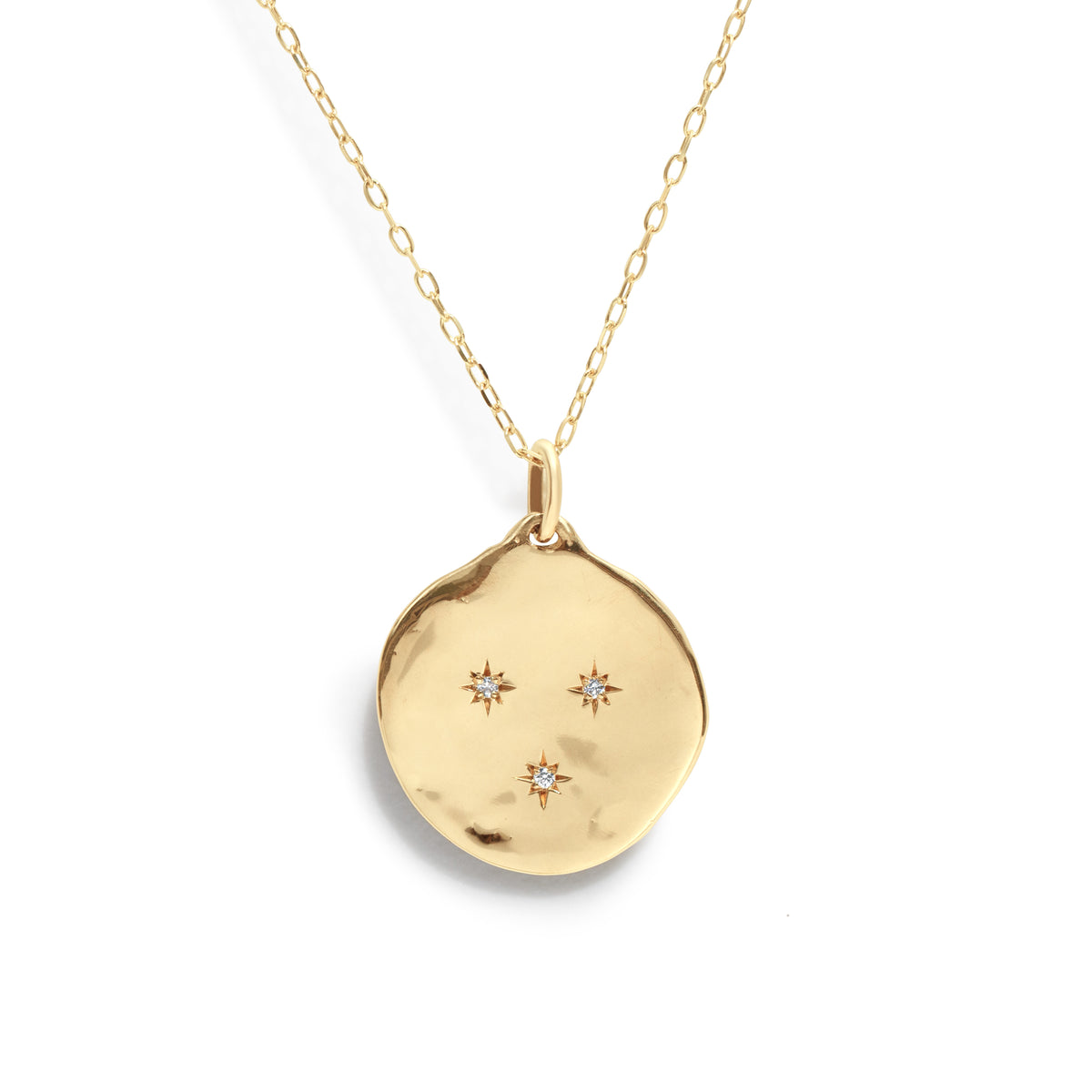 The Three Star Necklace features a hand-forged 14K gold round charm, adorned with three starburst-set natural diamonds at its center. 