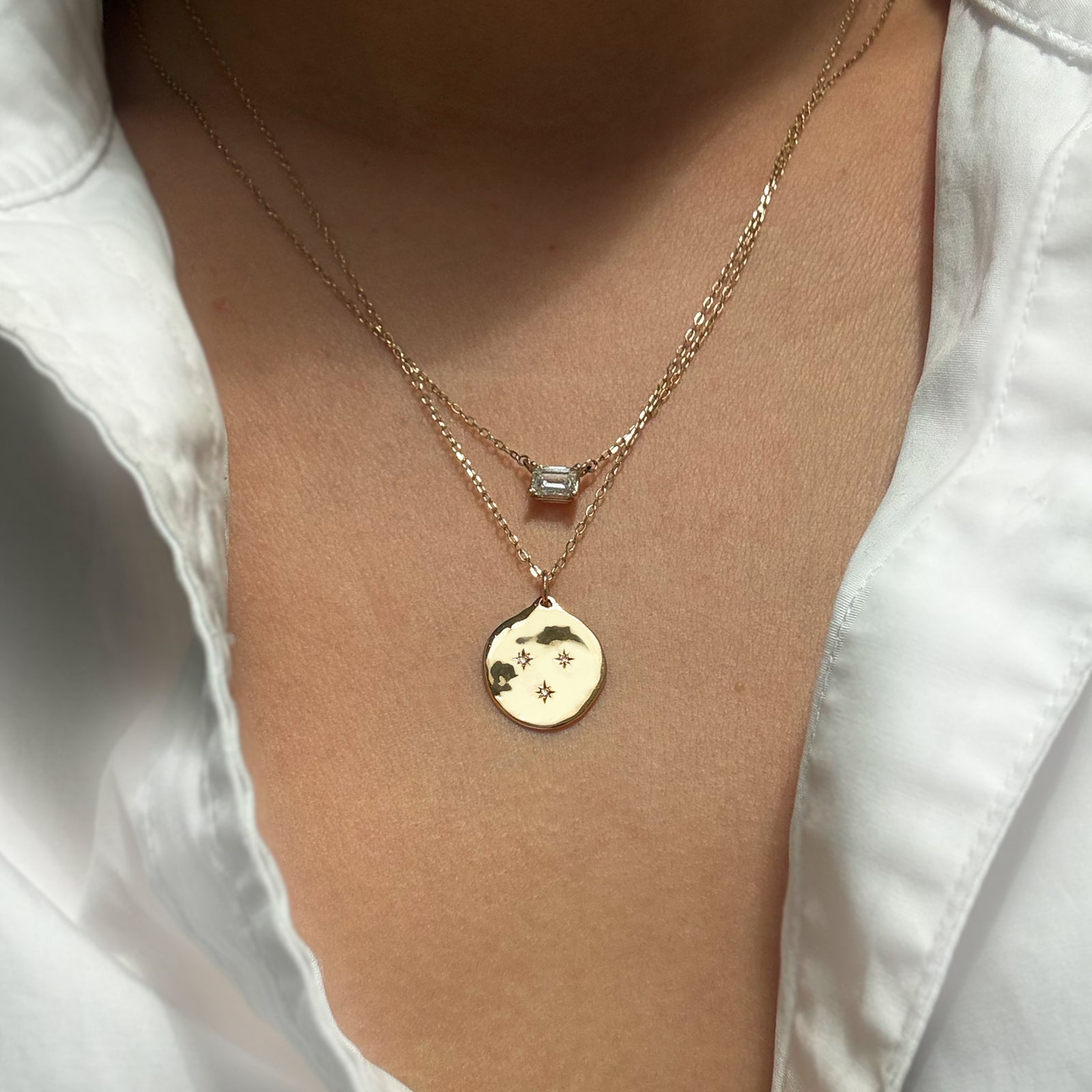 The Three Star Necklace features a hand-forged 14K gold round charm, adorned with three starburst-set natural diamonds at its center. 