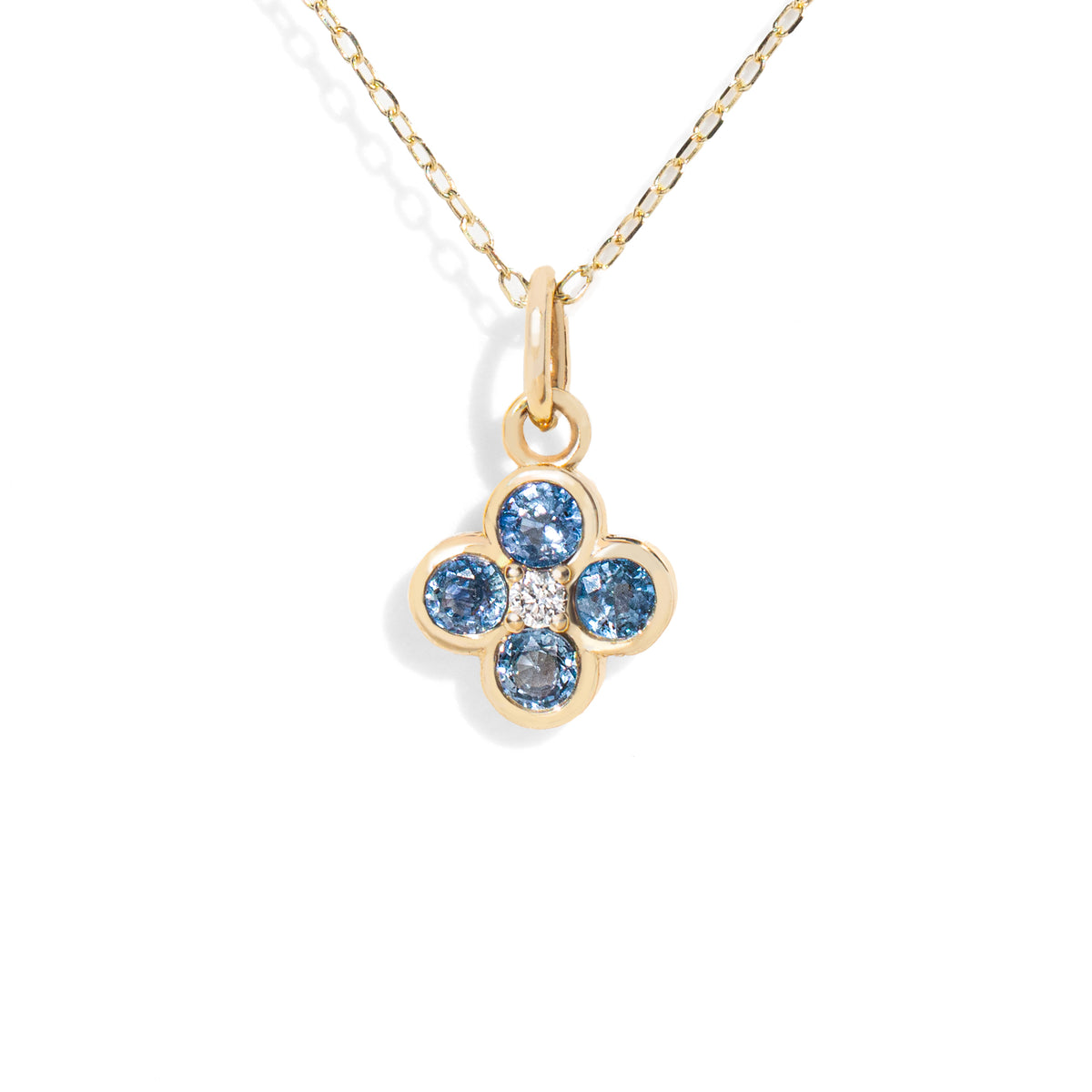 Gold necklace with a flower-shaped pendant featuring blue gemstones on a white background