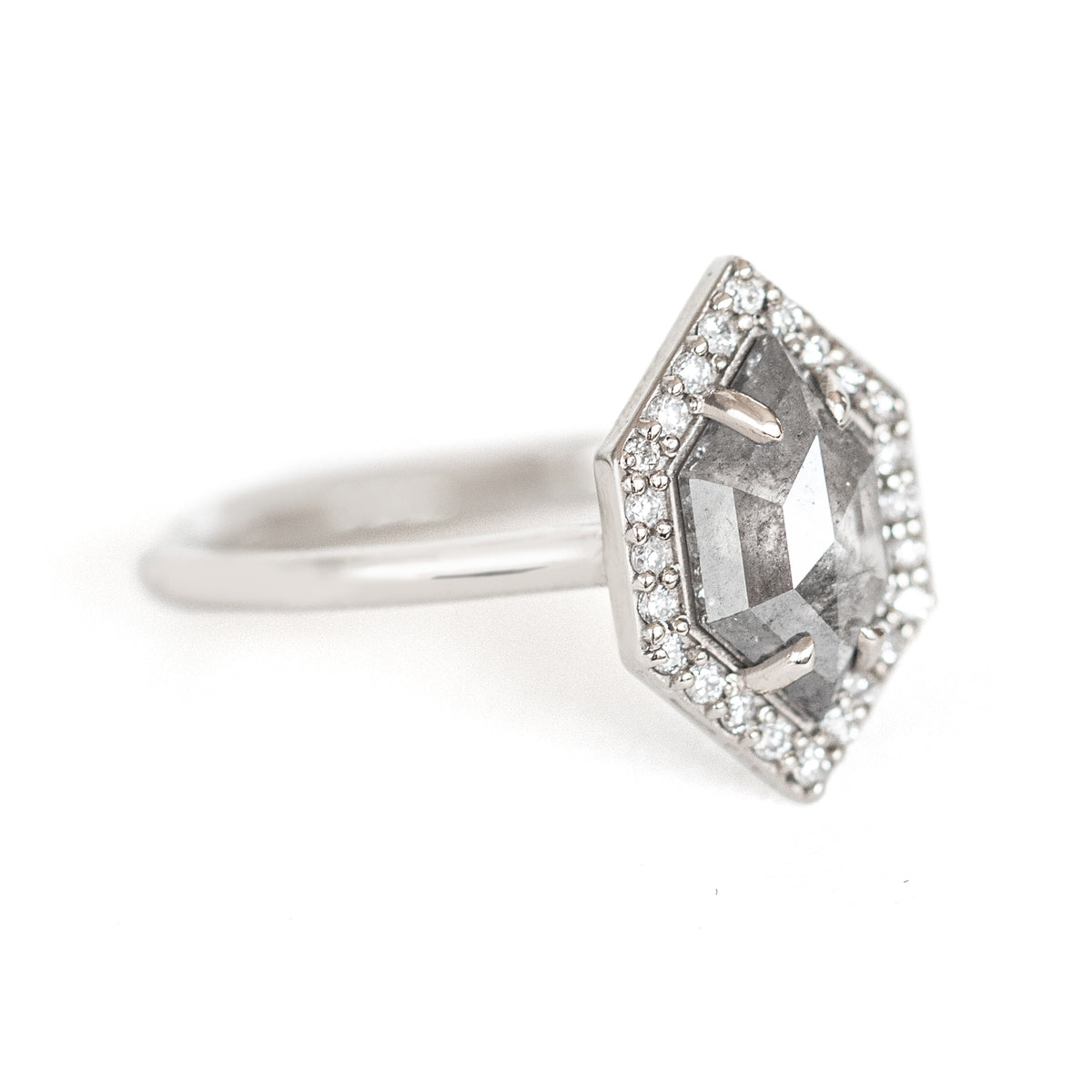 The Dunn 1.52 ct. Salt and Pepper Diamond Halo Ring is an absolute show-stopper. It features a modern hexagon diamond surrounded by a sparkling white diamond halo.