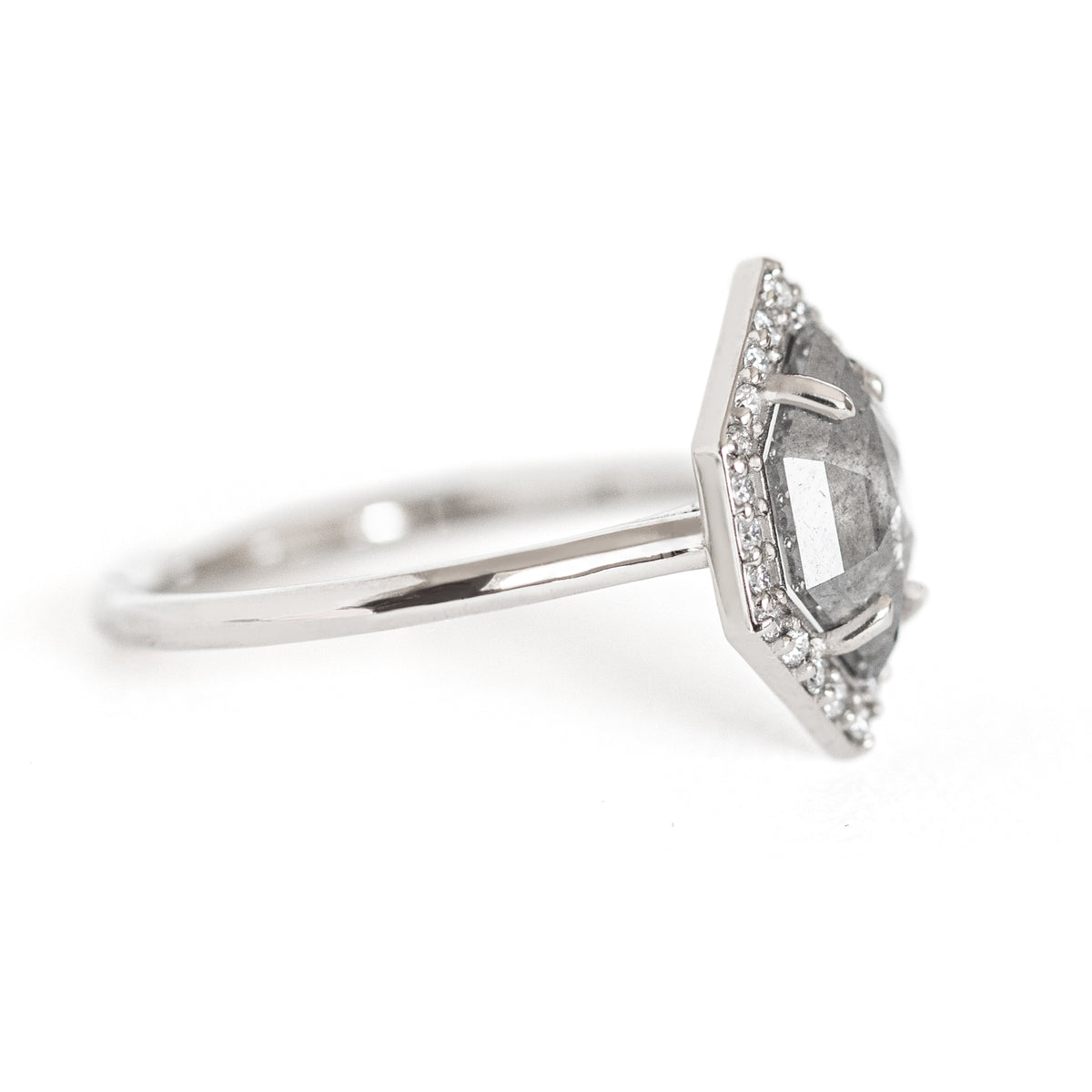 The Dunn 1.52 ct. Salt and Pepper Diamond Halo Ring is an absolute show-stopper. It features a modern hexagon diamond surrounded by a sparkling white diamond halo.