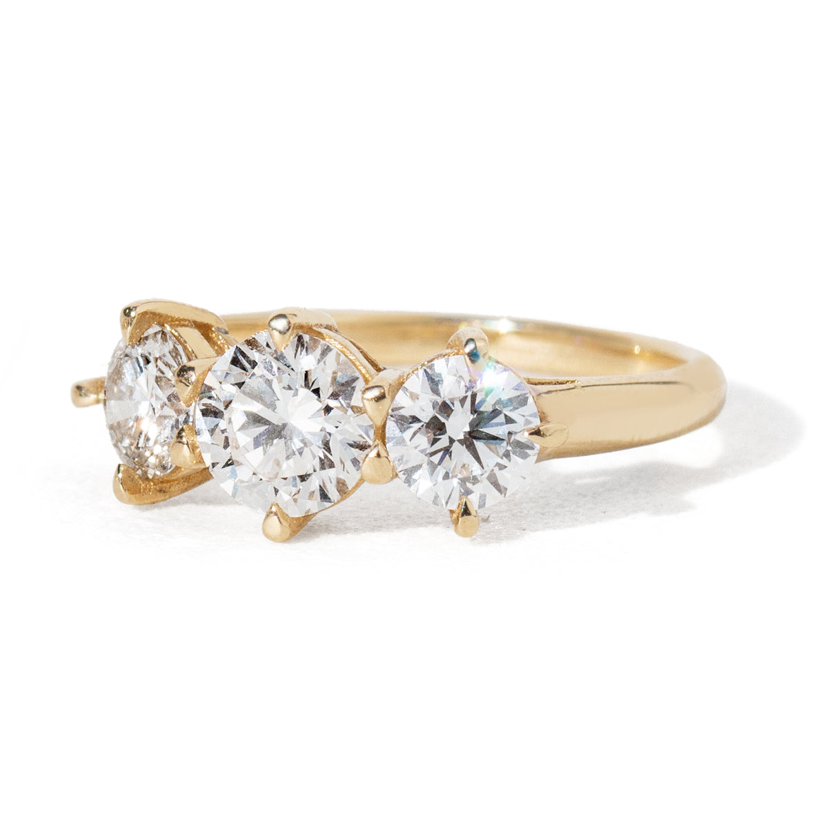 This three-diamond ring features a stunning 0.85-carat center diamond, flanked by two half-carat diamonds in our Empire design, representing a past-present-future or trinity ring. This luxurious piece effortlessly combines vintage charm with a modern aesthetic. It is the perfect choice for engagements, milestone celebrations, birthdays, and anniversaries, making it a versatile and timeless addition to any collection.