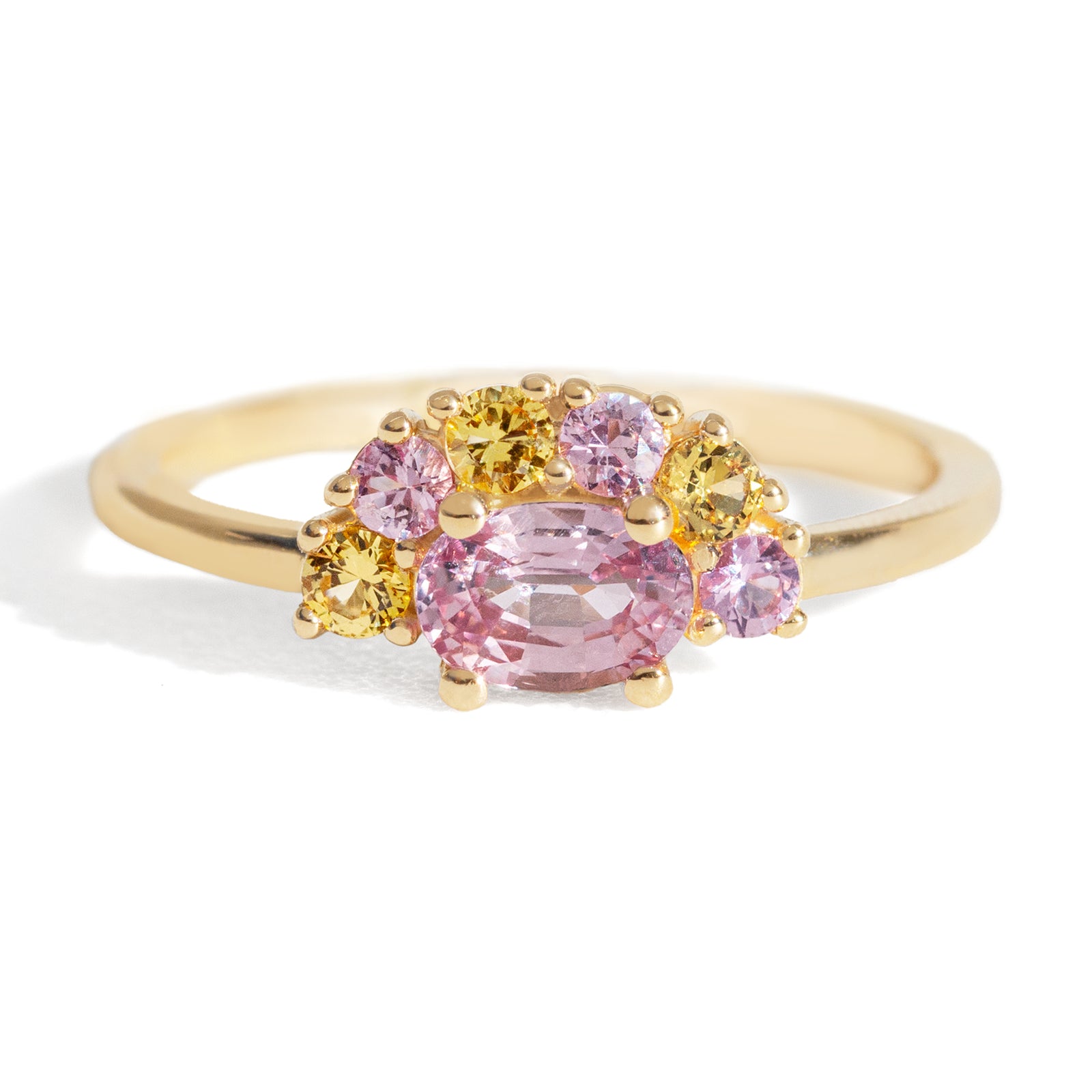 The 1.13 ctw. Pink and Yellow Sapphire Half Halo Ring features a 0.65 ct pink sapphire at its center, framed by a half halo of pink and yellow sapphires. The playful, colorful halo design is truly one of a kind. This ring is perfect for those who appreciate both colors and unique designs.