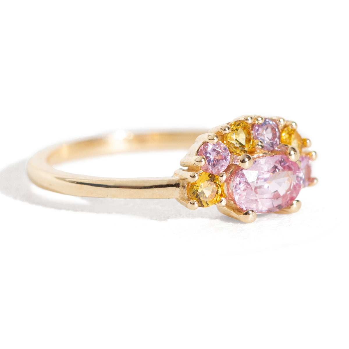 The 1.13 ctw. Pink and Yellow Sapphire Half Halo Ring features a 0.65 ct pink sapphire at its center, framed by a half halo of pink and yellow sapphires. The playful, colorful halo design is truly one of a kind. This ring is perfect for those who appreciate both colors and unique designs.