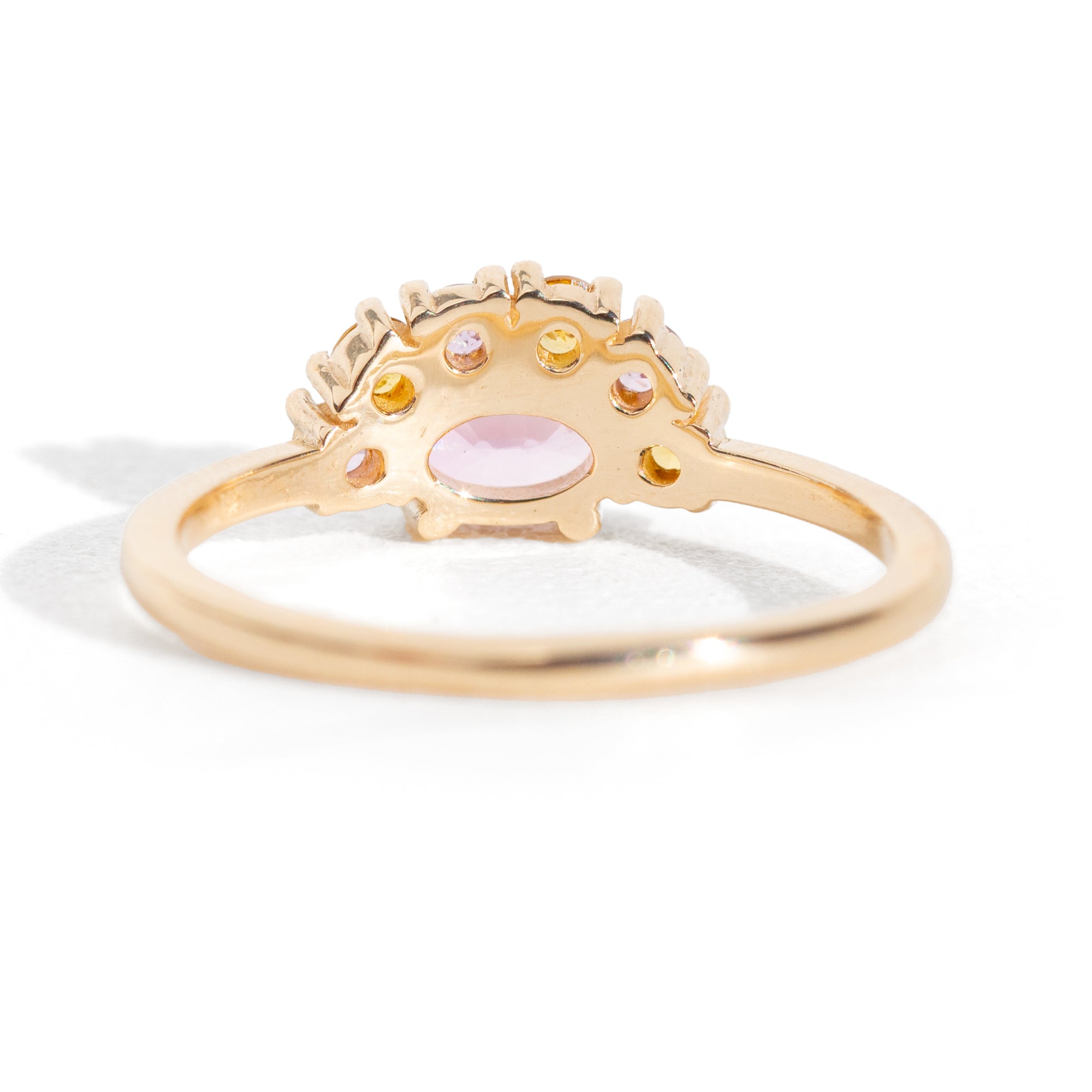 The 1.13 ctw. Pink and Yellow Sapphire Half Halo Ring features a 0.65 ct pink sapphire at its center, framed by a half halo of pink and yellow sapphires. The playful, colorful halo design is truly one of a kind. This ring is perfect for those who appreciate both colors and unique designs.