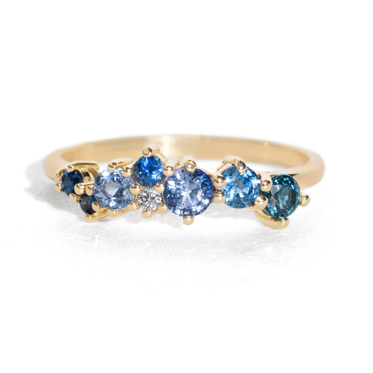 Gold ring with blue gemstones on a white background
