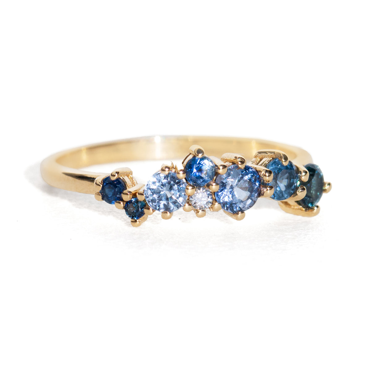 Gold ring with blue gemstones on a white background