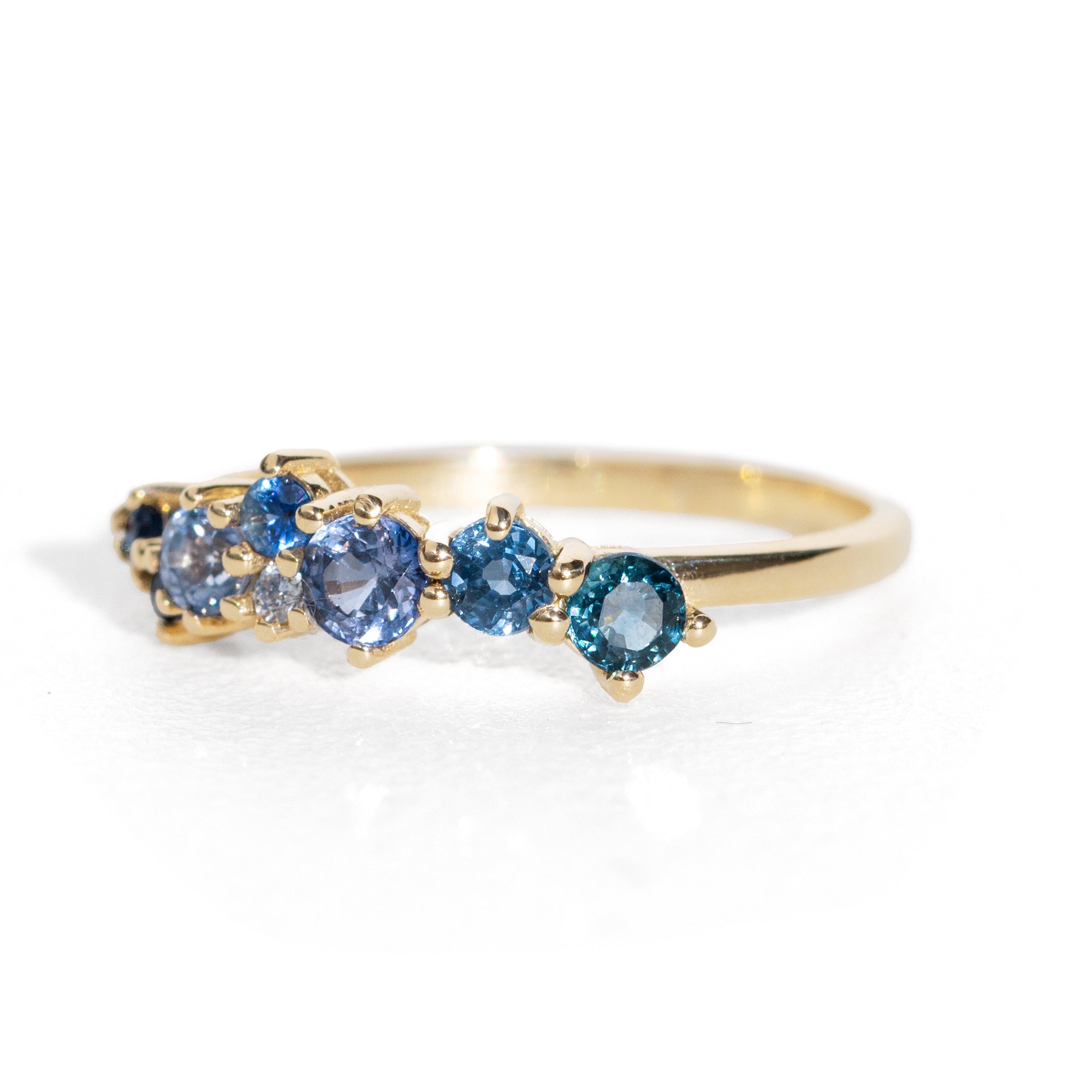 Gold ring with blue gemstones on a white background