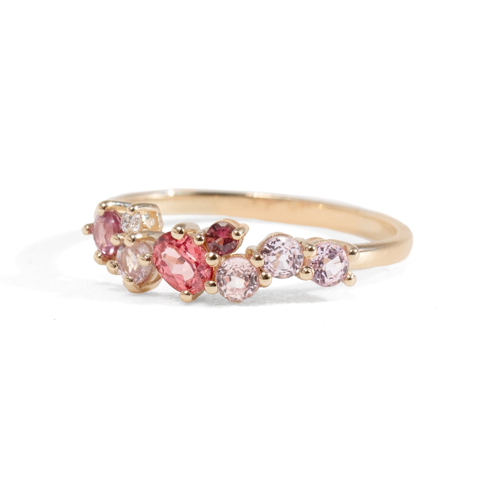 Gold ring with pink gemstones on a white background