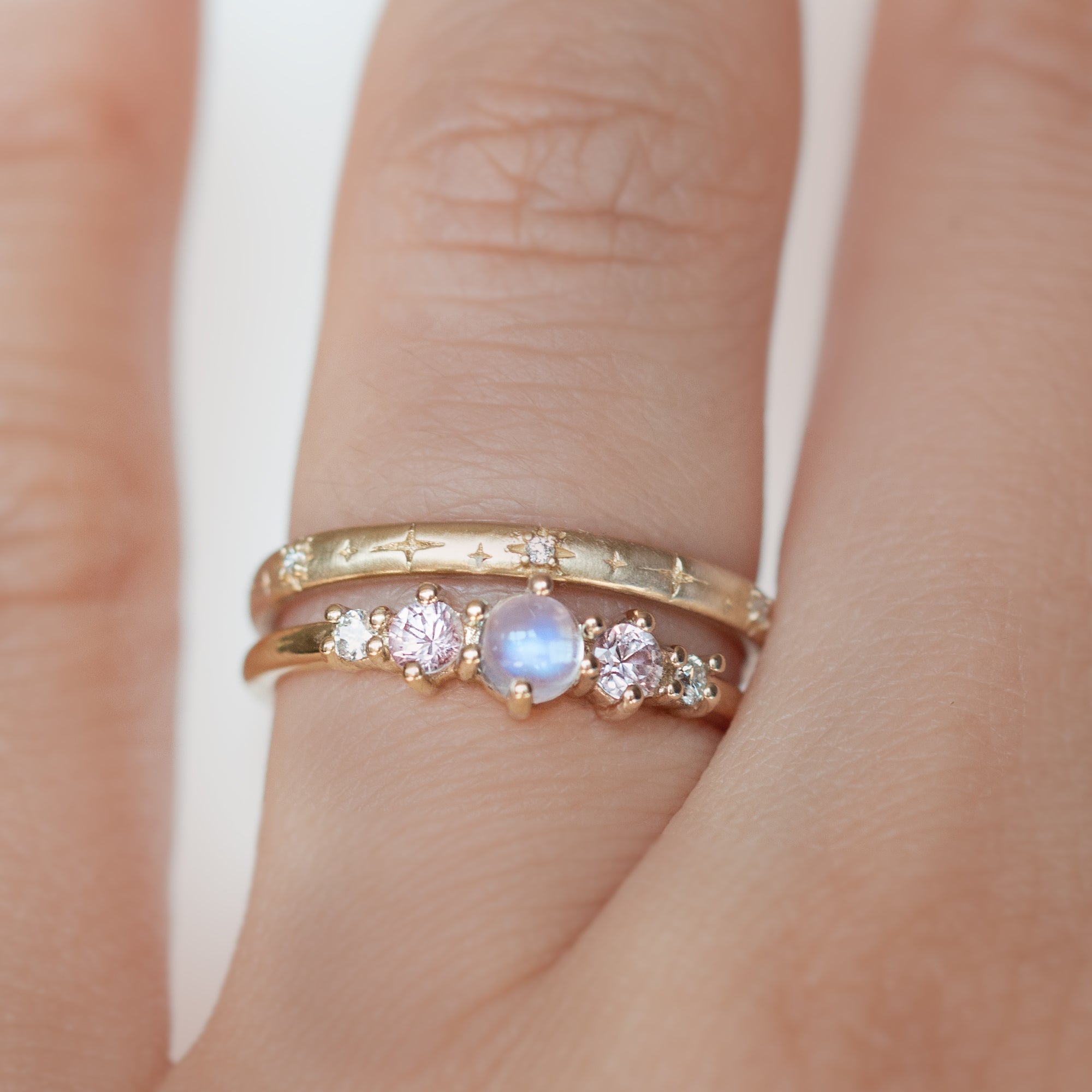 The classic Georgia design makes this five stone ring ideal for everyday wear. This unique ring features a round rainbow moonstone, adorned with natural pink sapphires and diamonds, and exudes mystical purple blue hues, making it a true unicorn piece.