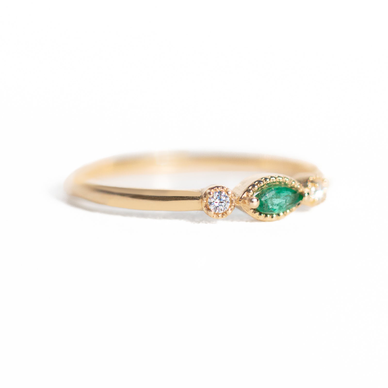 Made for vintage lovers, this Marquise Emerald Three Stone Ring features a bold green emerald in a marquise cut, complemented by sparkling diamonds on either side, all set in a beautiful milgrain setting. Its elegant yet understated design makes it ideal for everyday wear, a thoughtful gift, or as a delicate engagement ring.