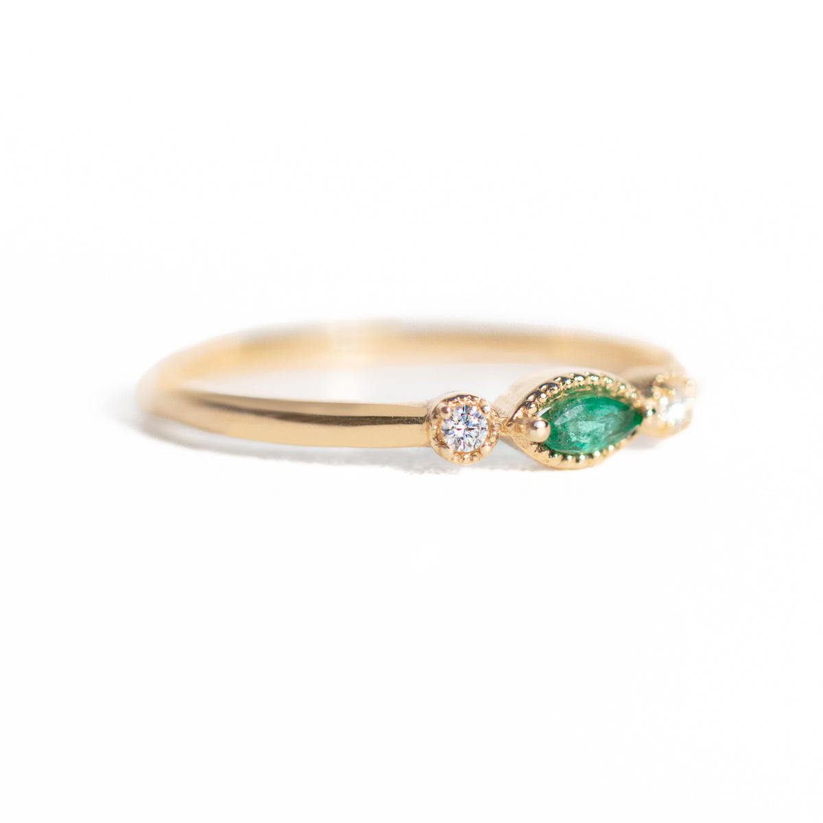 Made for vintage lovers, this Marquise Emerald Three Stone Ring features a bold green emerald in a marquise cut, complemented by sparkling diamonds on either side, all set in a beautiful milgrain setting. Its elegant yet understated design makes it ideal for everyday wear, a thoughtful gift, or as a delicate engagement ring.