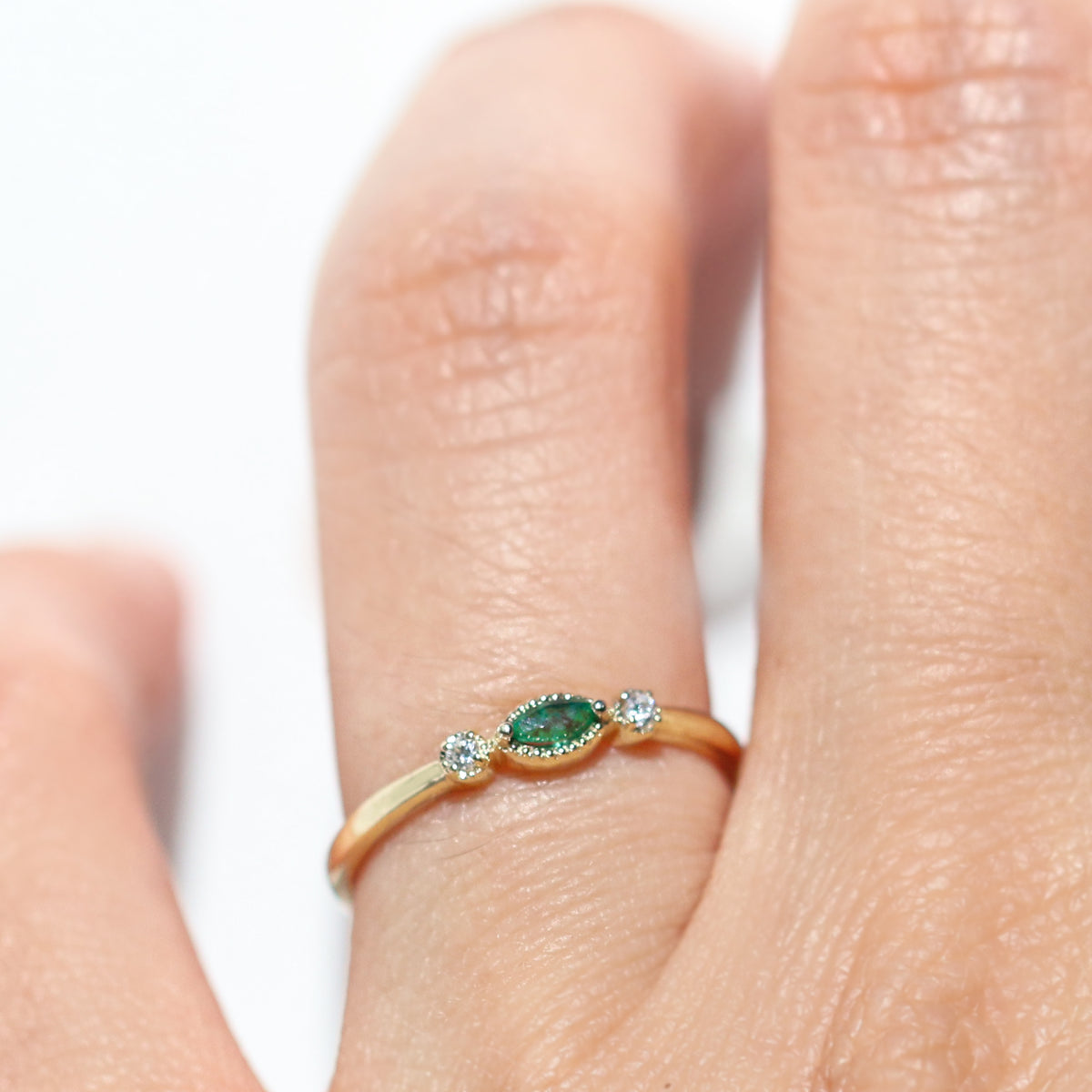 Made for vintage lovers, this Marquise Emerald Three Stone Ring features a bold green emerald in a marquise cut, complemented by sparkling diamonds on either side, all set in a beautiful milgrain setting. Its elegant yet understated design makes it ideal for everyday wear, a thoughtful gift, or as a delicate engagement ring.
