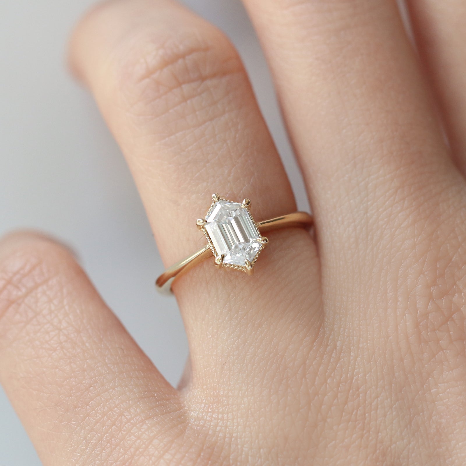 The Hera Ring showcases a 1.5ct hexagon lab diamond or moissanite, with a delicately highlighted hexagon step cut and milgrain accents on the setting. This elegant and romantic ring effortlessly combines antique charm with a modern aesthetic. It serves as the perfect choice for engagements, milestone celebrations, birthdays, and anniversaries, making it a versatile and timeless piece.