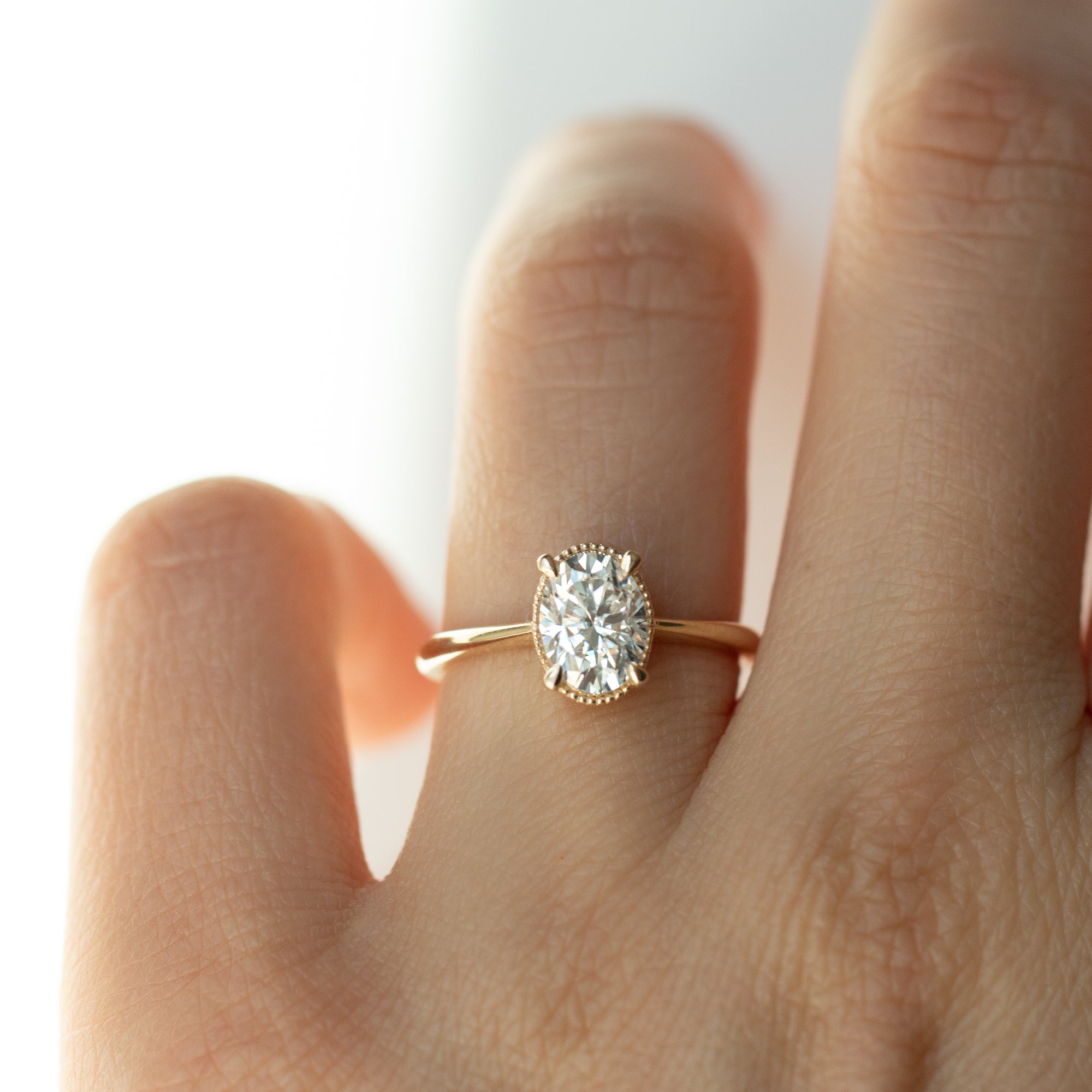 The Hera Ring features a 1ct. oval diamond or moissanite set in a delicately milgrained setting. This elegant and romantic design effortlessly blends old-world charm with a modern aesthetic. It’s the perfect choice for engagements, milestone celebrations, birthdays, and anniversaries, making it a timeless piece.