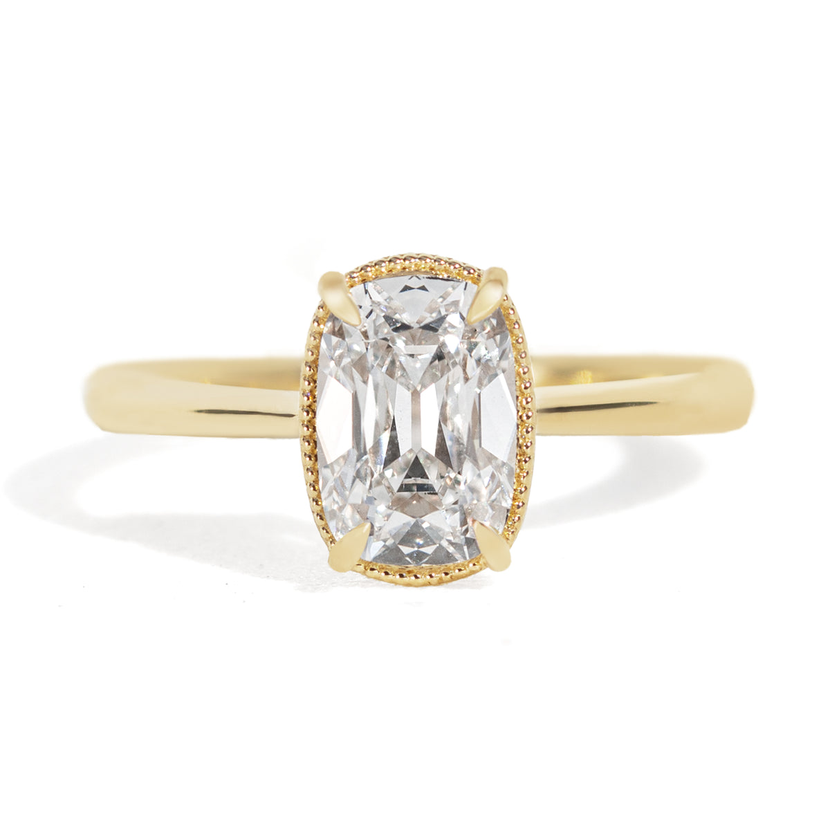 Gold milgrain ring with a 1.5 carat old mine cut diamond on a white background