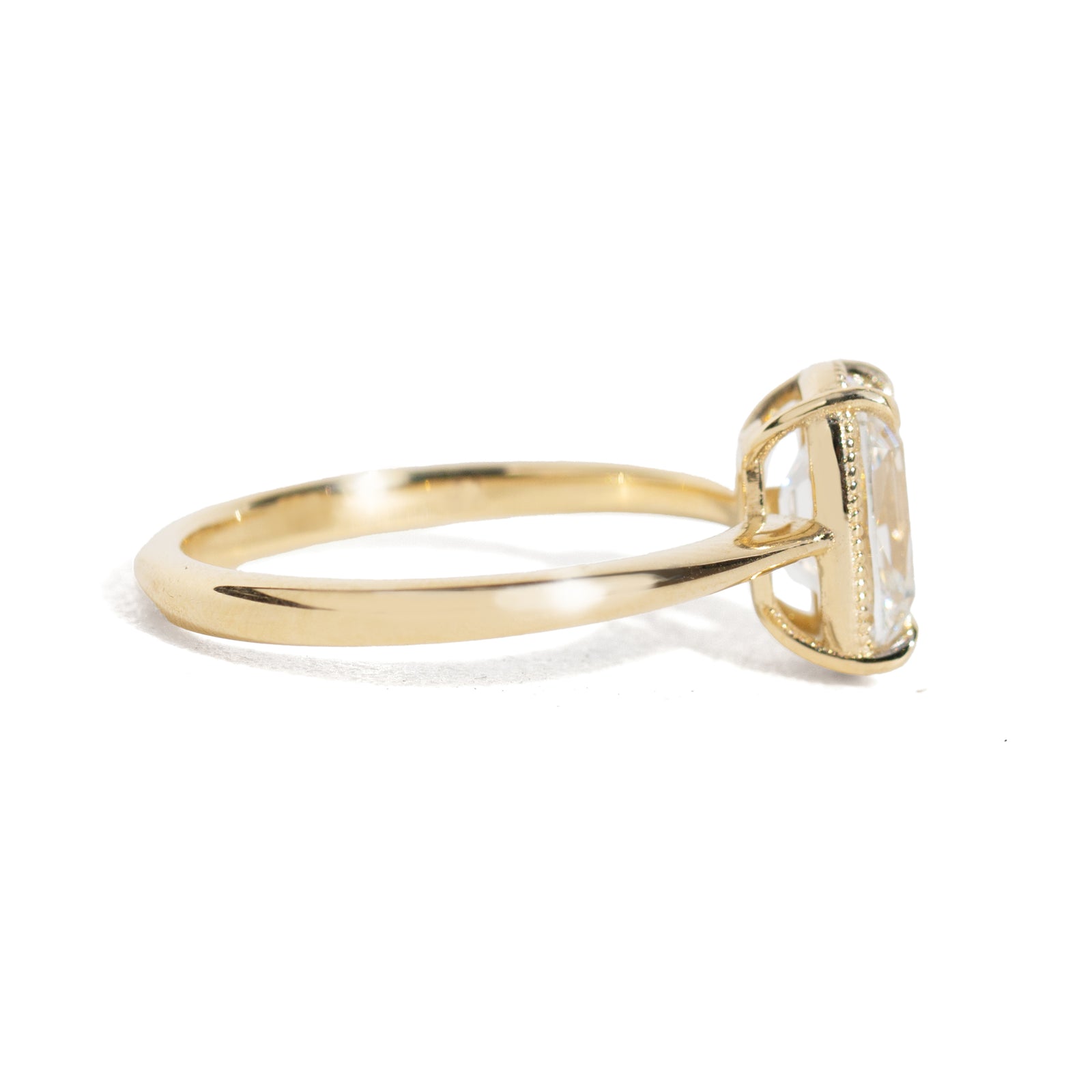 Gold milgrain ring with a 1.5 carat old mine cut diamond on a white background
